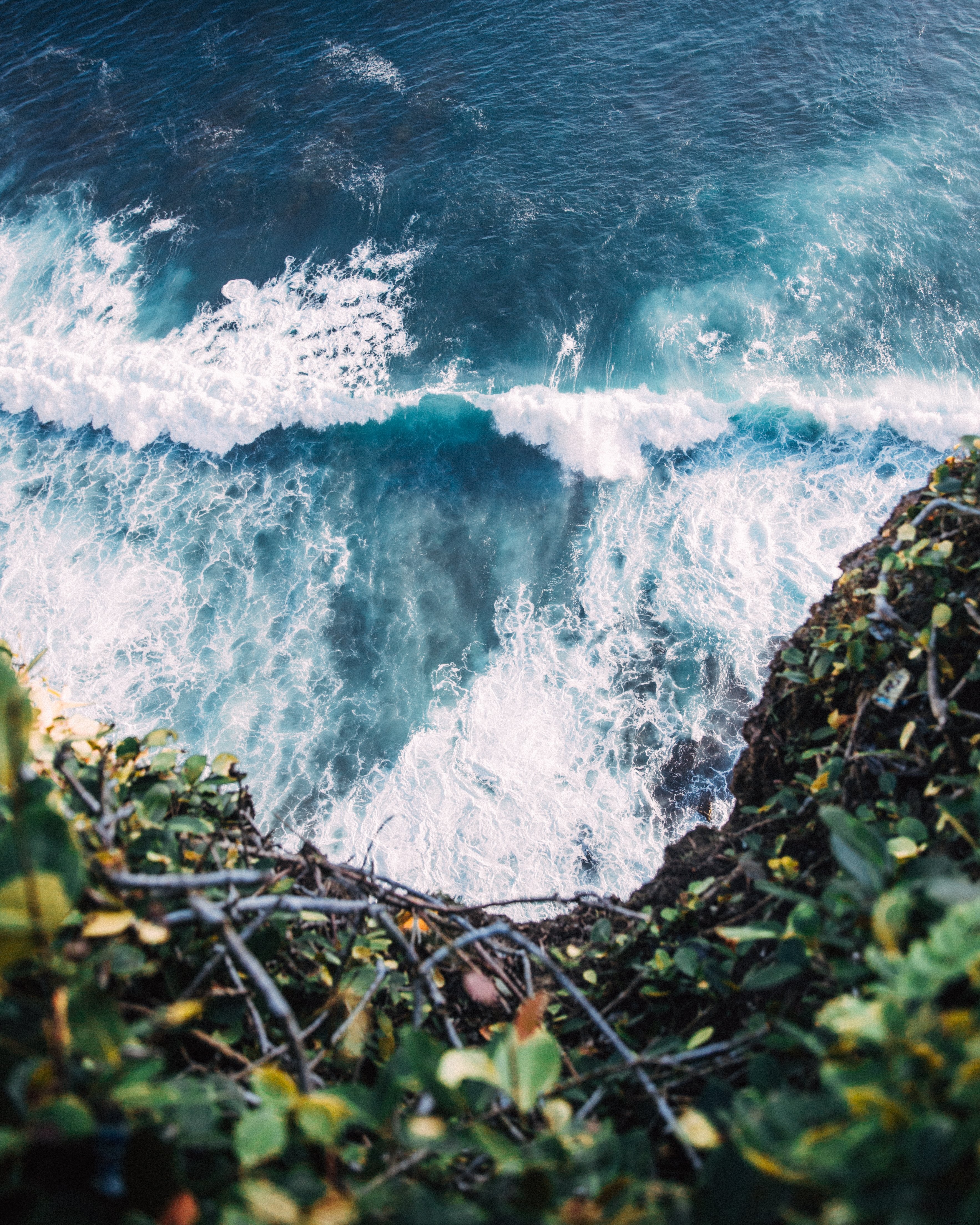 Le onde blu si infrangono alla base della scogliera foto