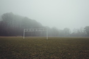 Vista inquietante di un campo di calcio nebbioso foto