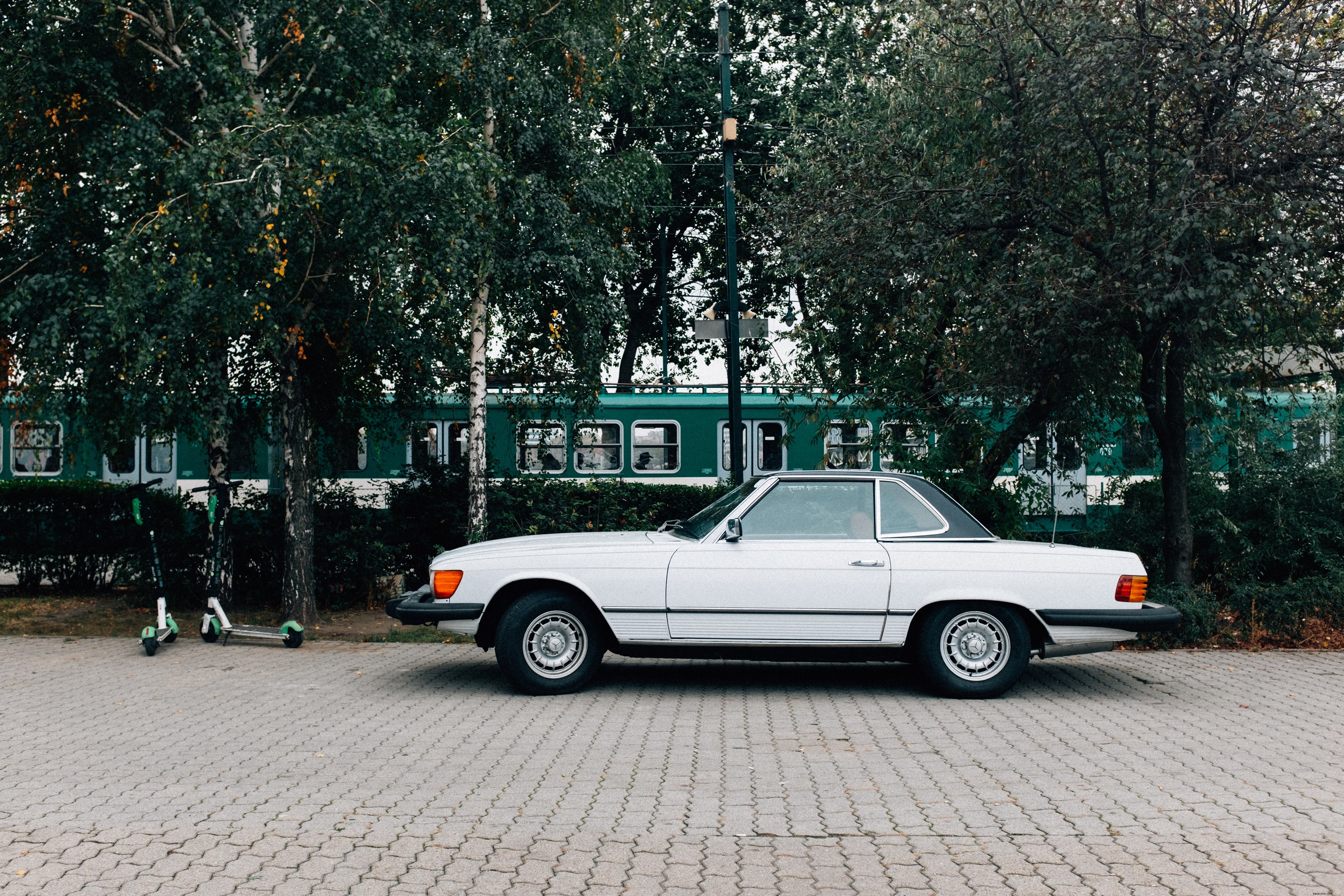 Coche clásico aparcado bajo los árboles Foto