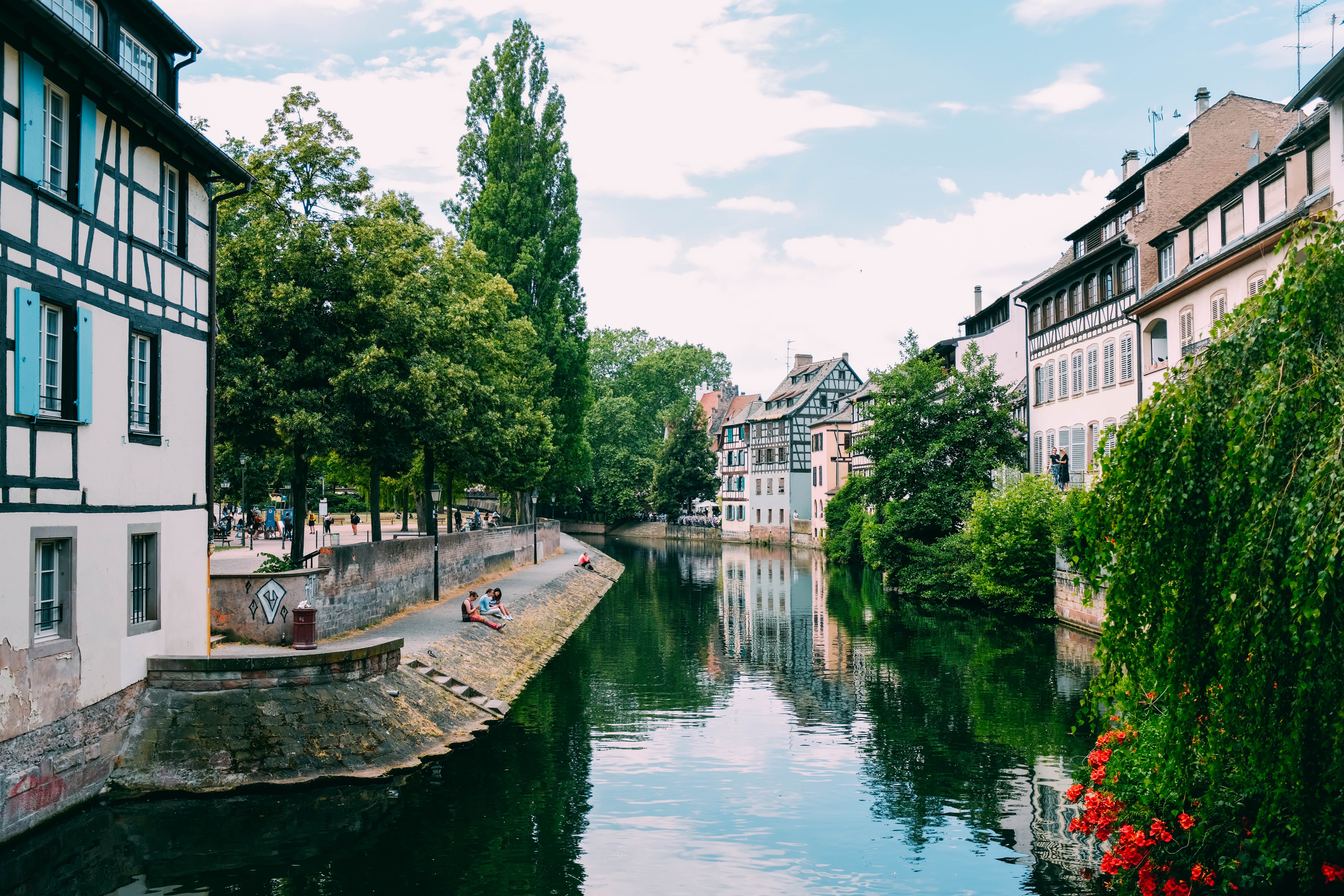 Un río pasa junto a edificios históricos y árboles foto