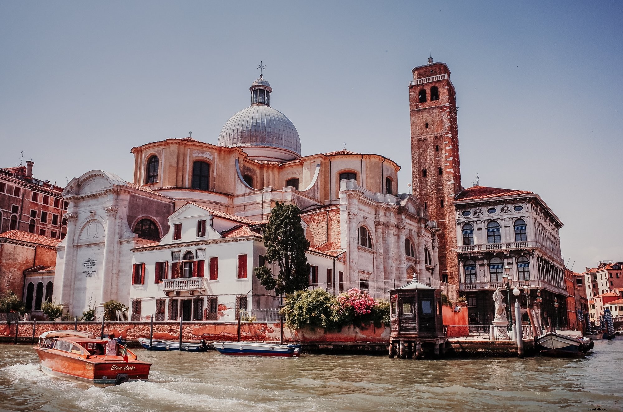 Alto edificio bianco con acqua color ruggine davanti foto