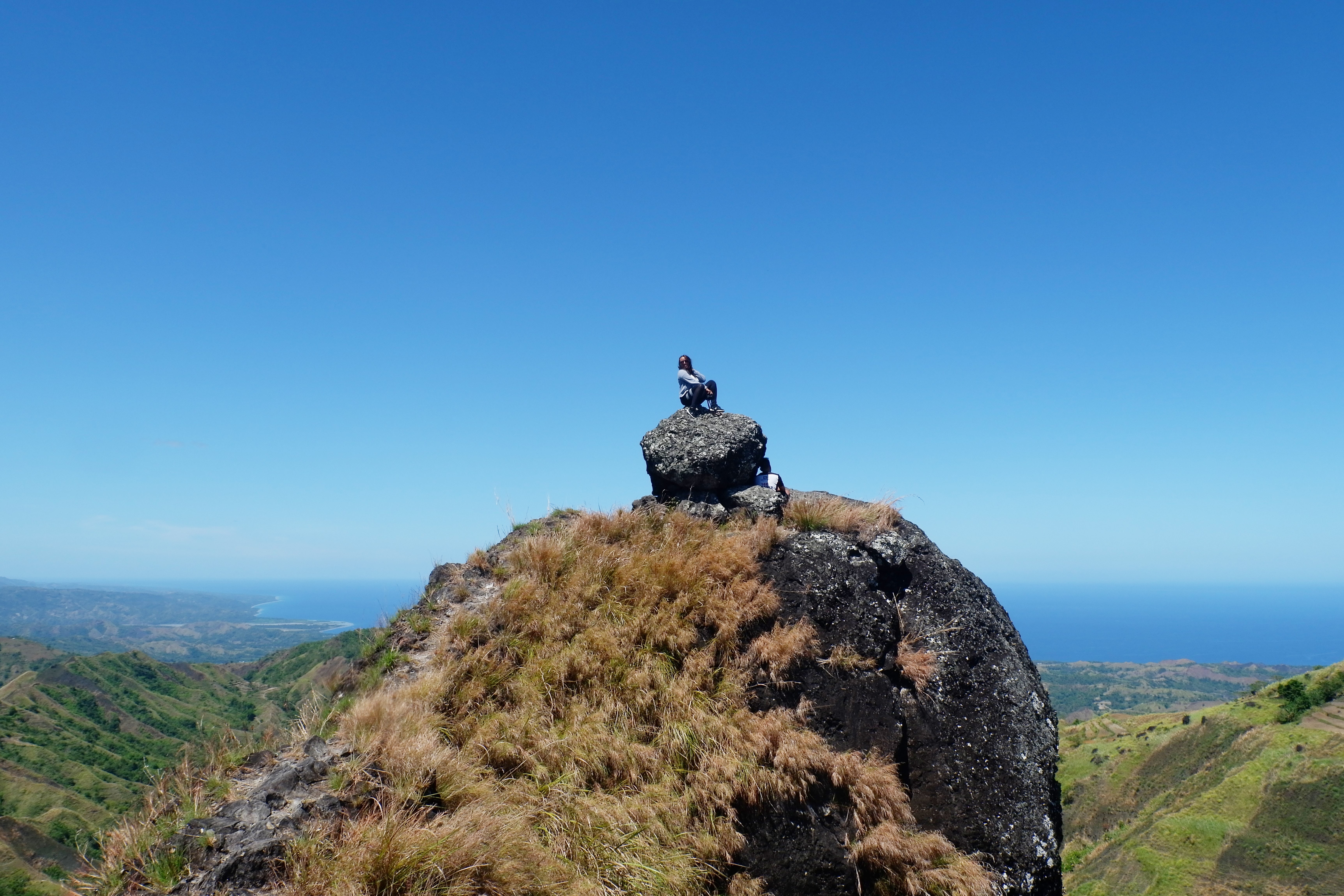 L escursionista riposa sulla roccia sopra la foto del paesaggio