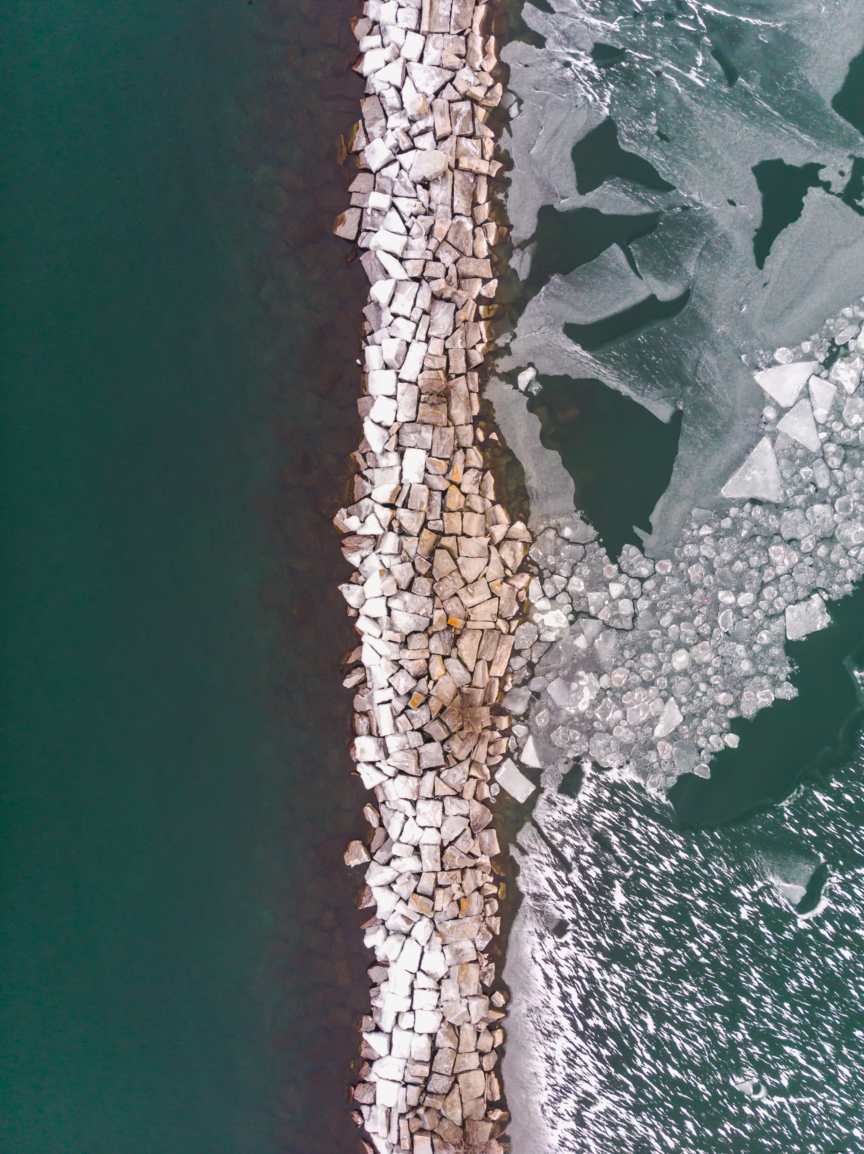 Rocce che separano acqua limpida e ghiaccio foto