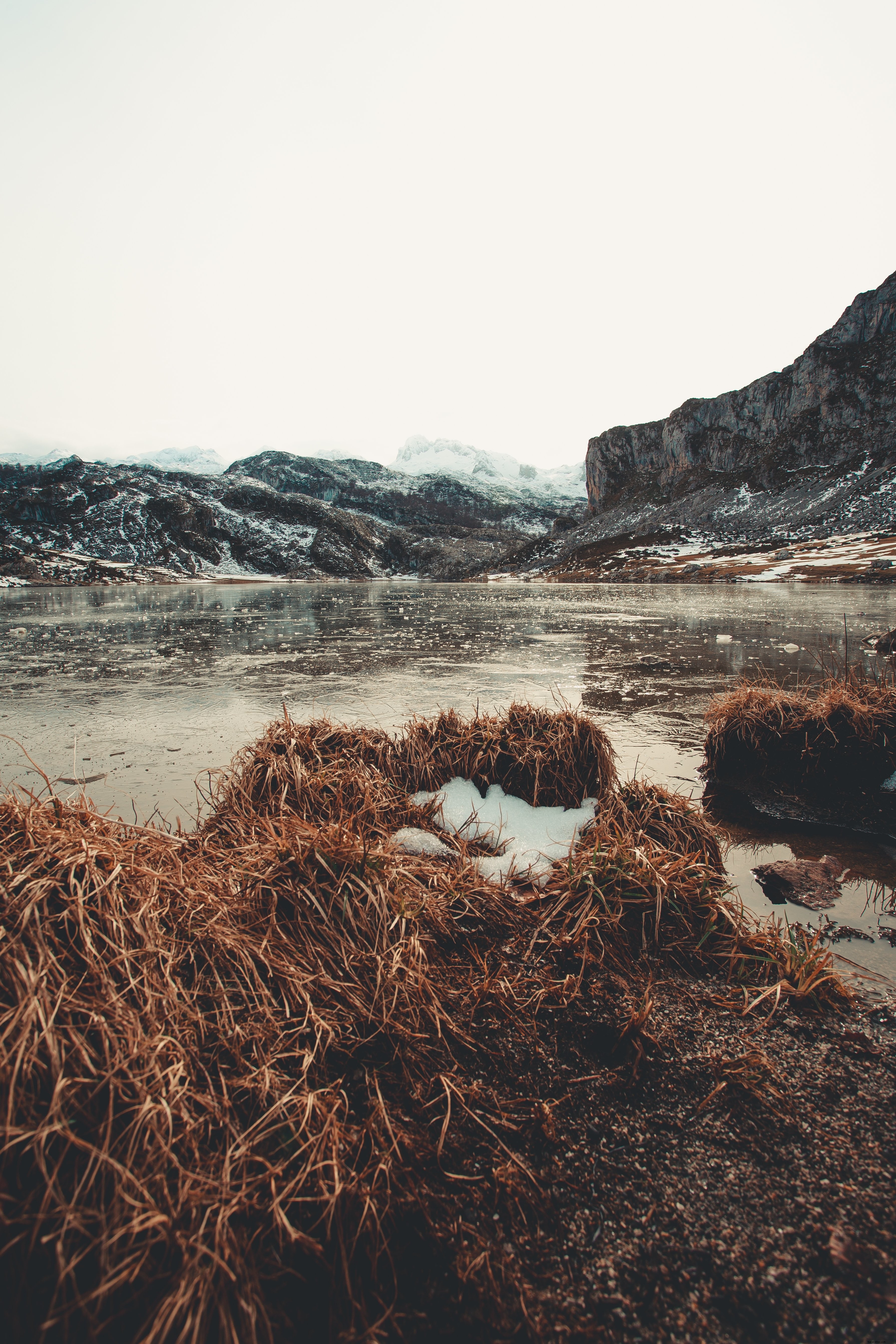 Foto de lago helado antes de montañas nevadas