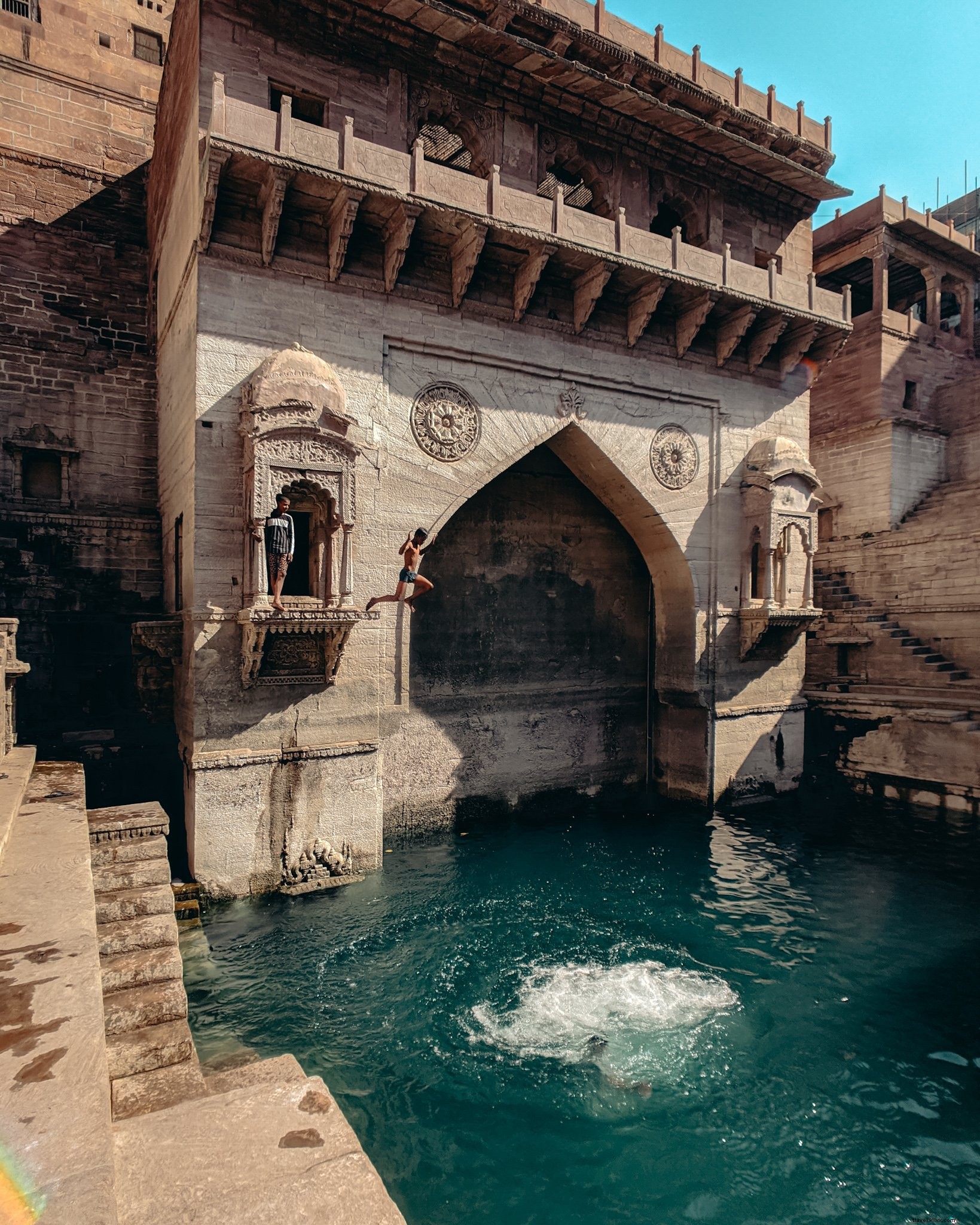 Les gens sautent dans l eau depuis une alcôve en pierre Photo