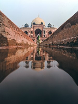 Água de um canal estreito reflete a foto do Taj Mahal