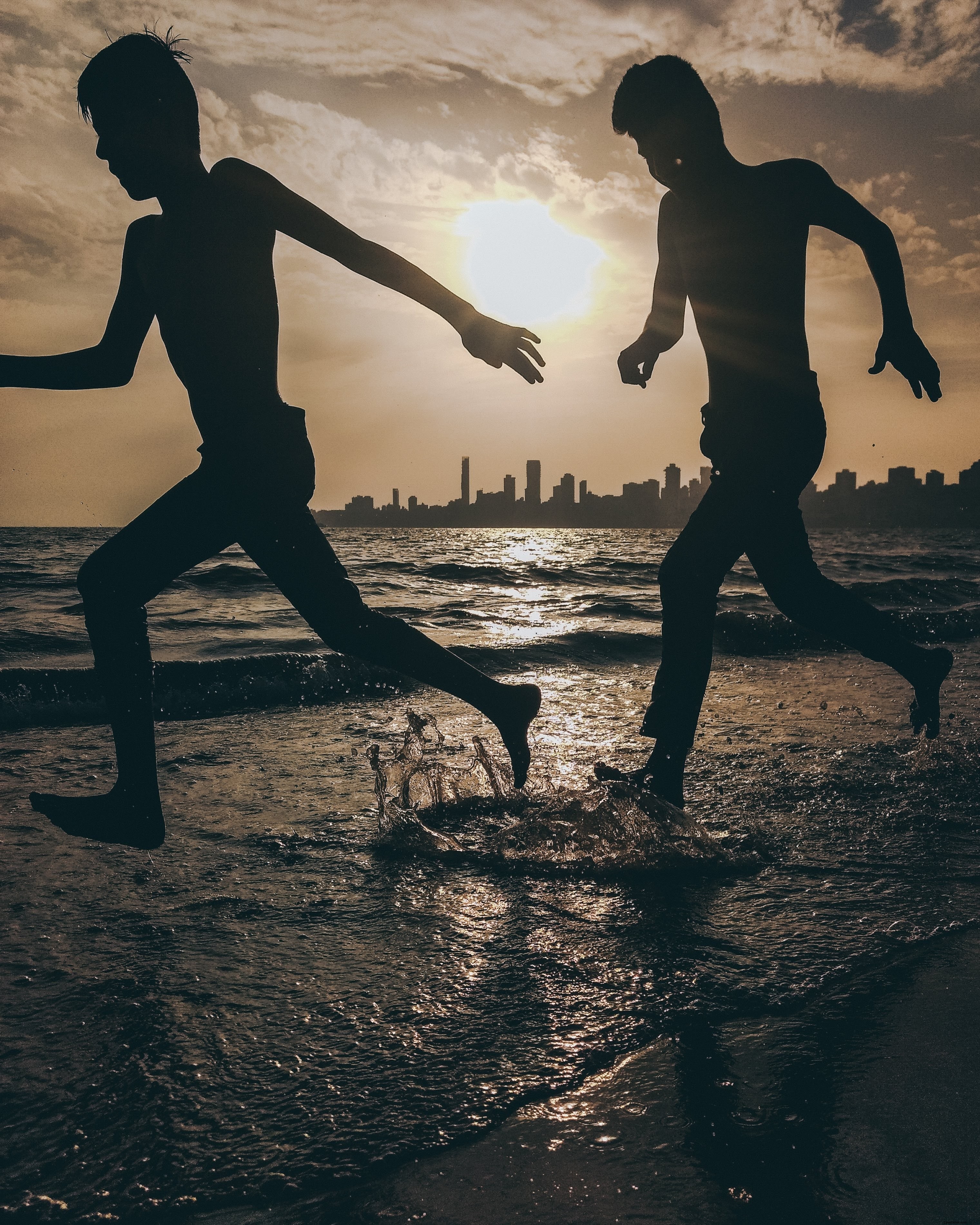 Sagome di due persone che si tuffano sulla spiaggia foto