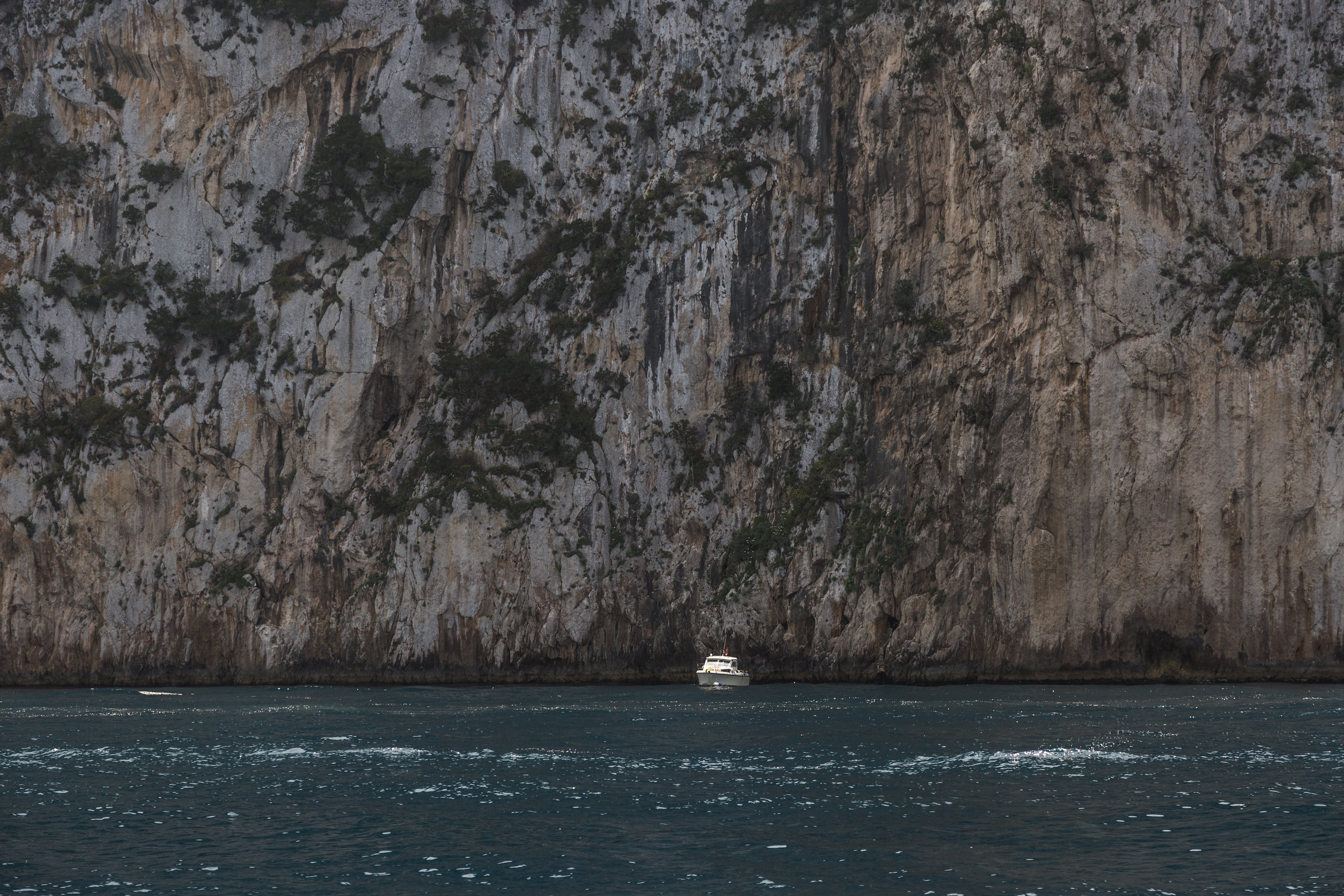 Barco frente a una enorme foto de acantilado 