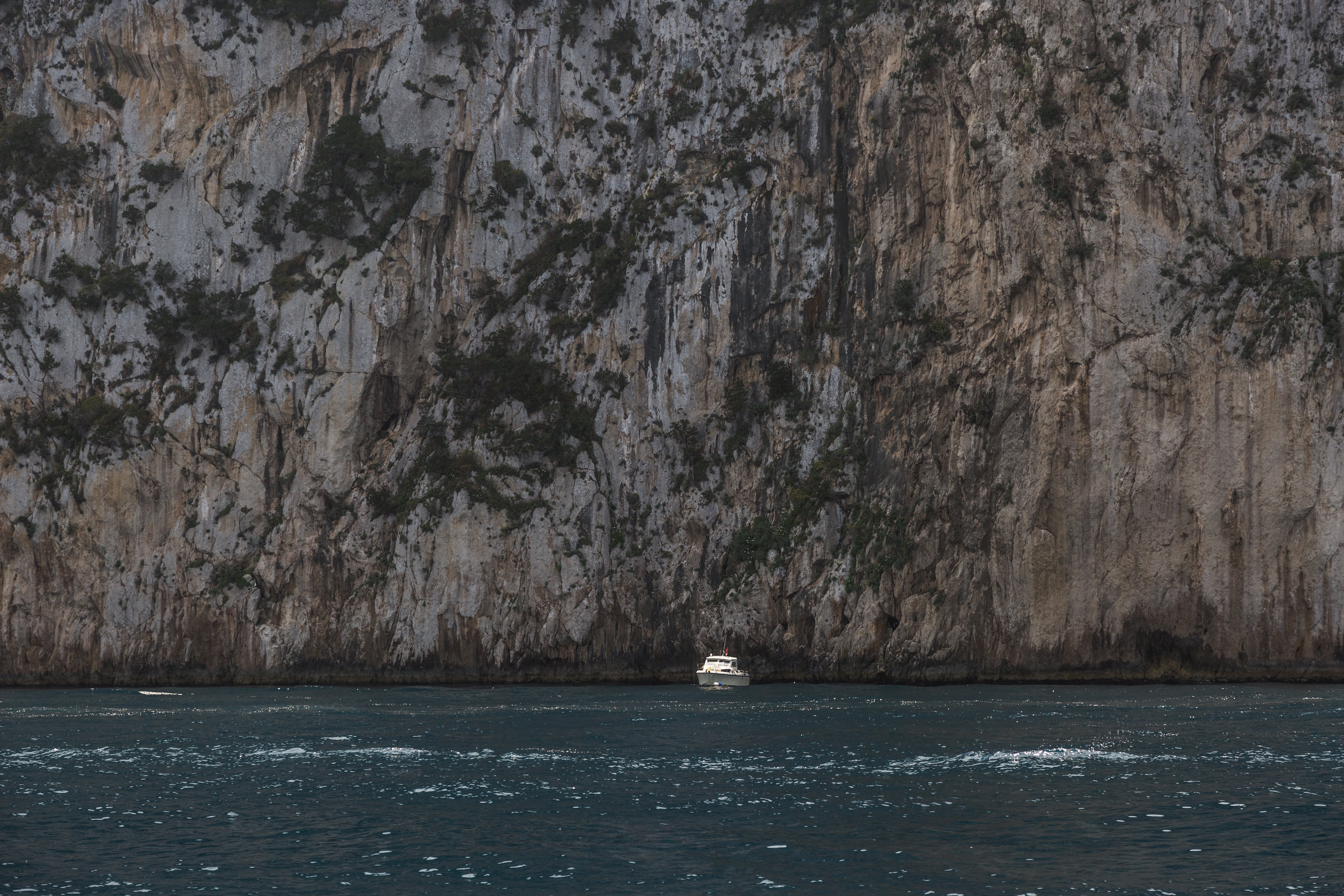 Bateau devant une immense falaise Photo 