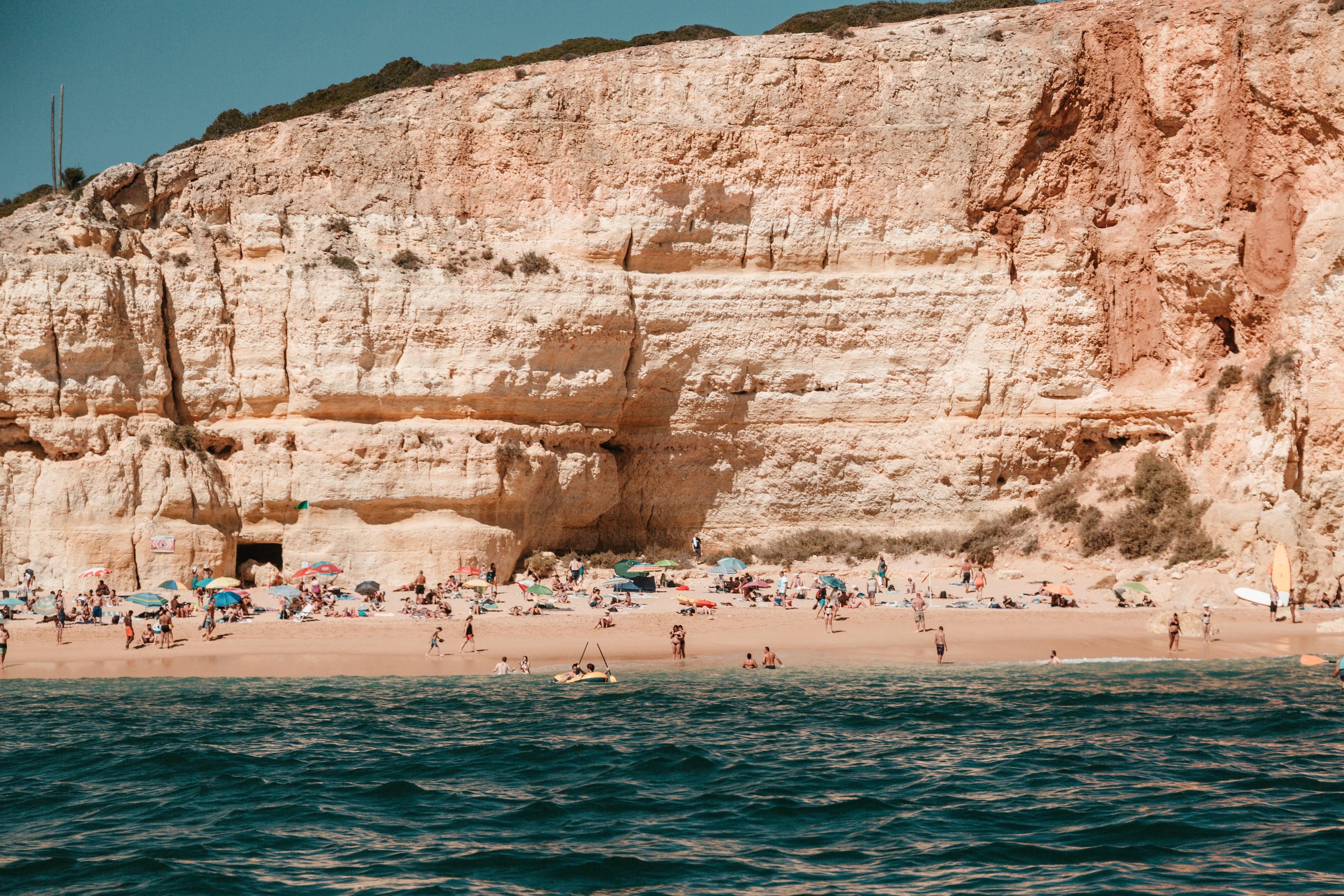 Baigneurs sur une plage de sable contre une falaise escarpée Photo 