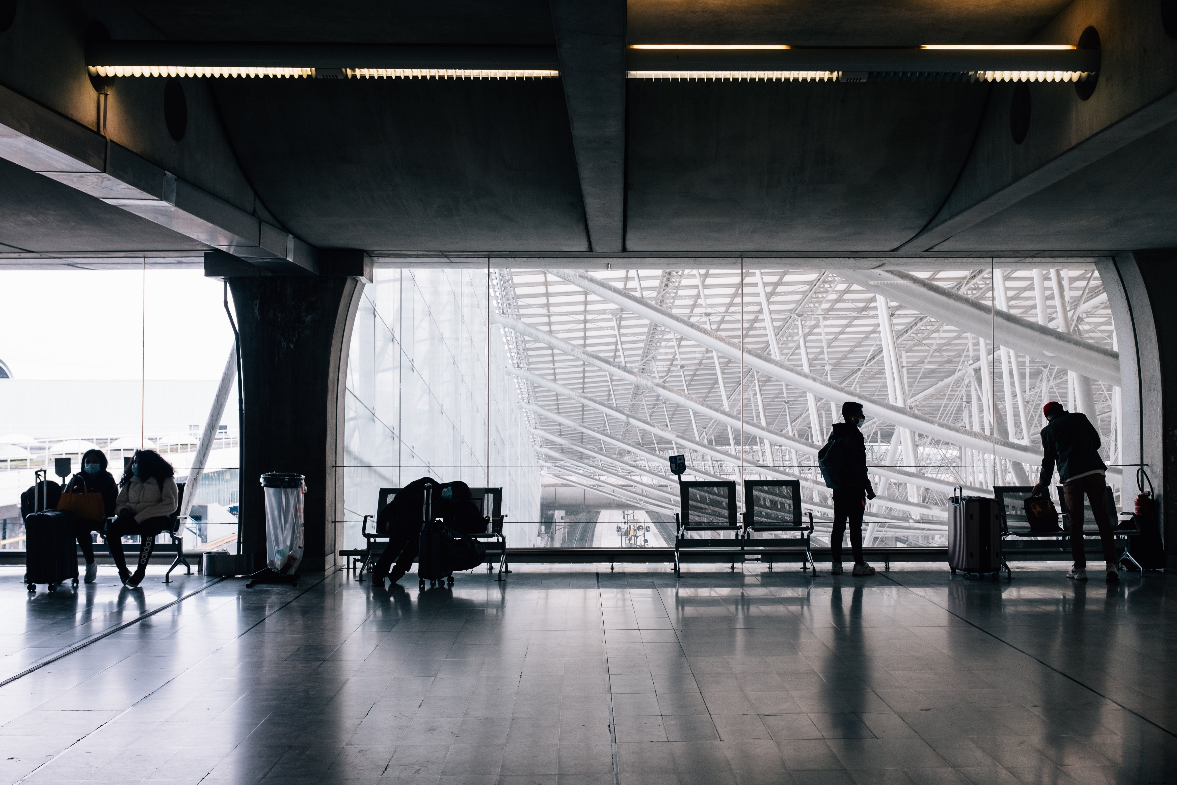 Le persone aspettano di viaggiare con bagagli e mascherine foto 