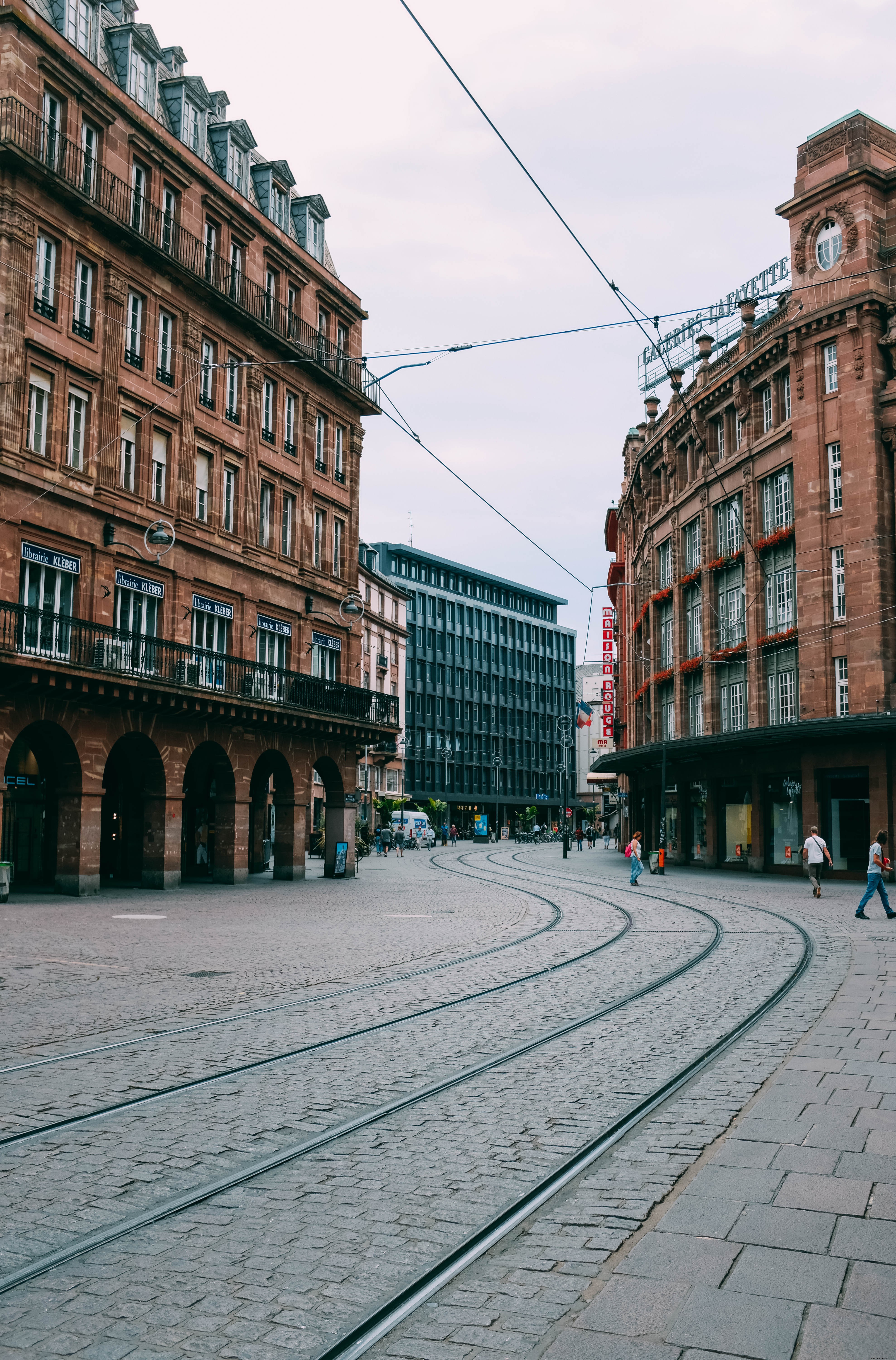 Edifici in mattoni rossi e linee del tram nelle strade di ciottoli Foto 