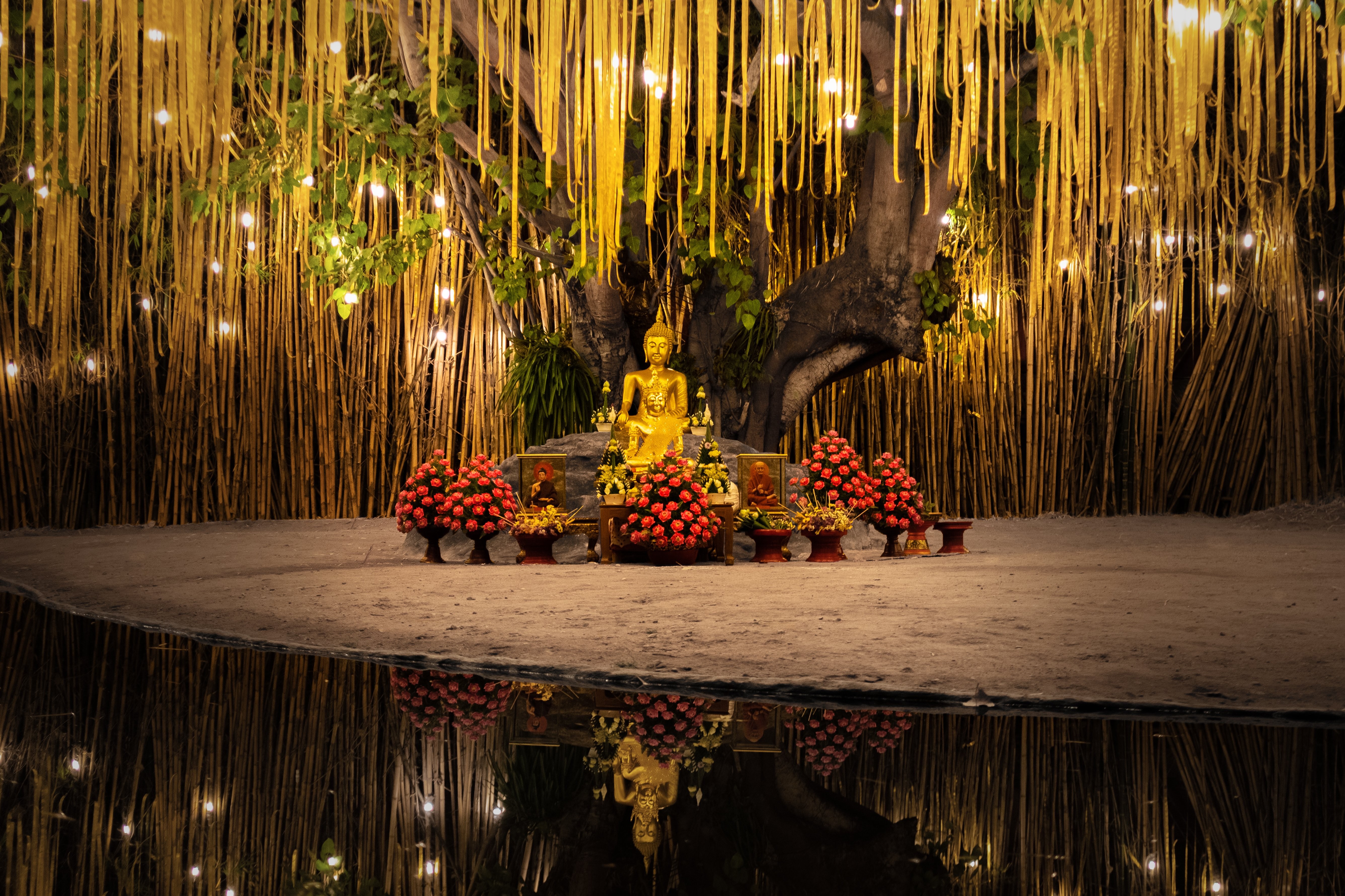 Foto de estatuas budistas rodeadas de flores 