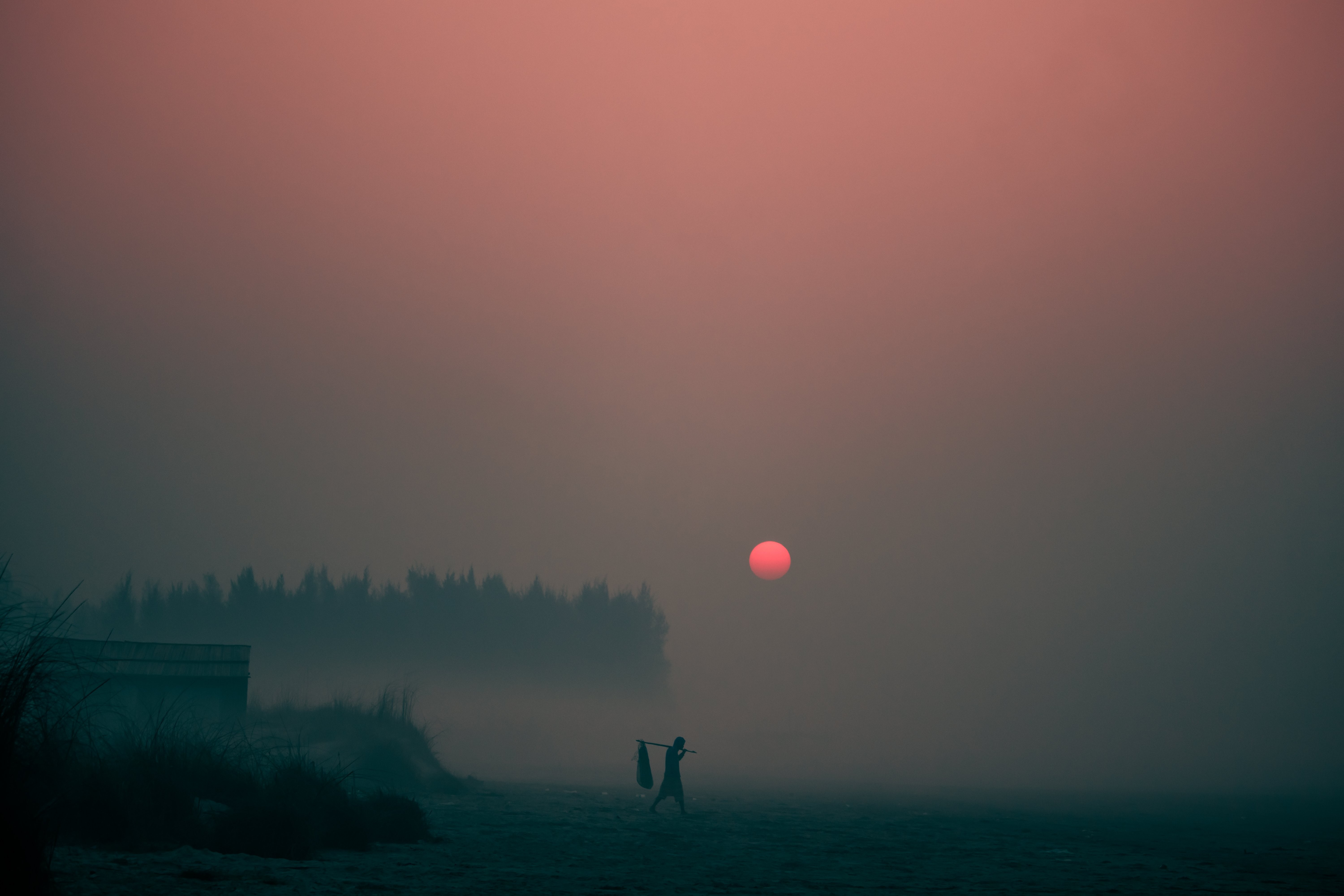 Il sole tramonta attraverso una fitta nebbia serale 