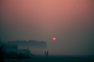 濃い夜の霧の中から太陽が沈む写真 
