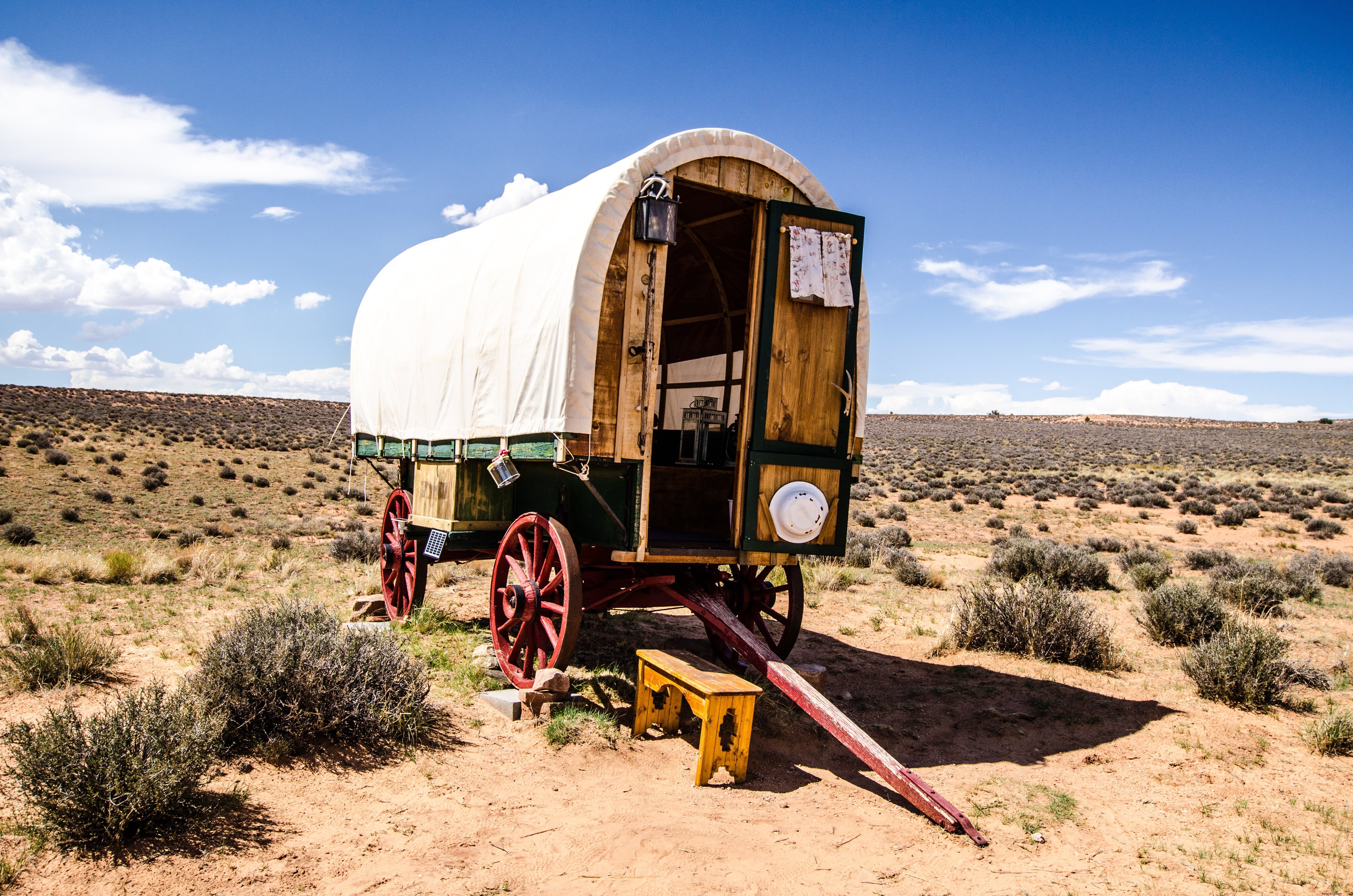 Uma caravana tradicional repousa sob o céu azul na planície. 