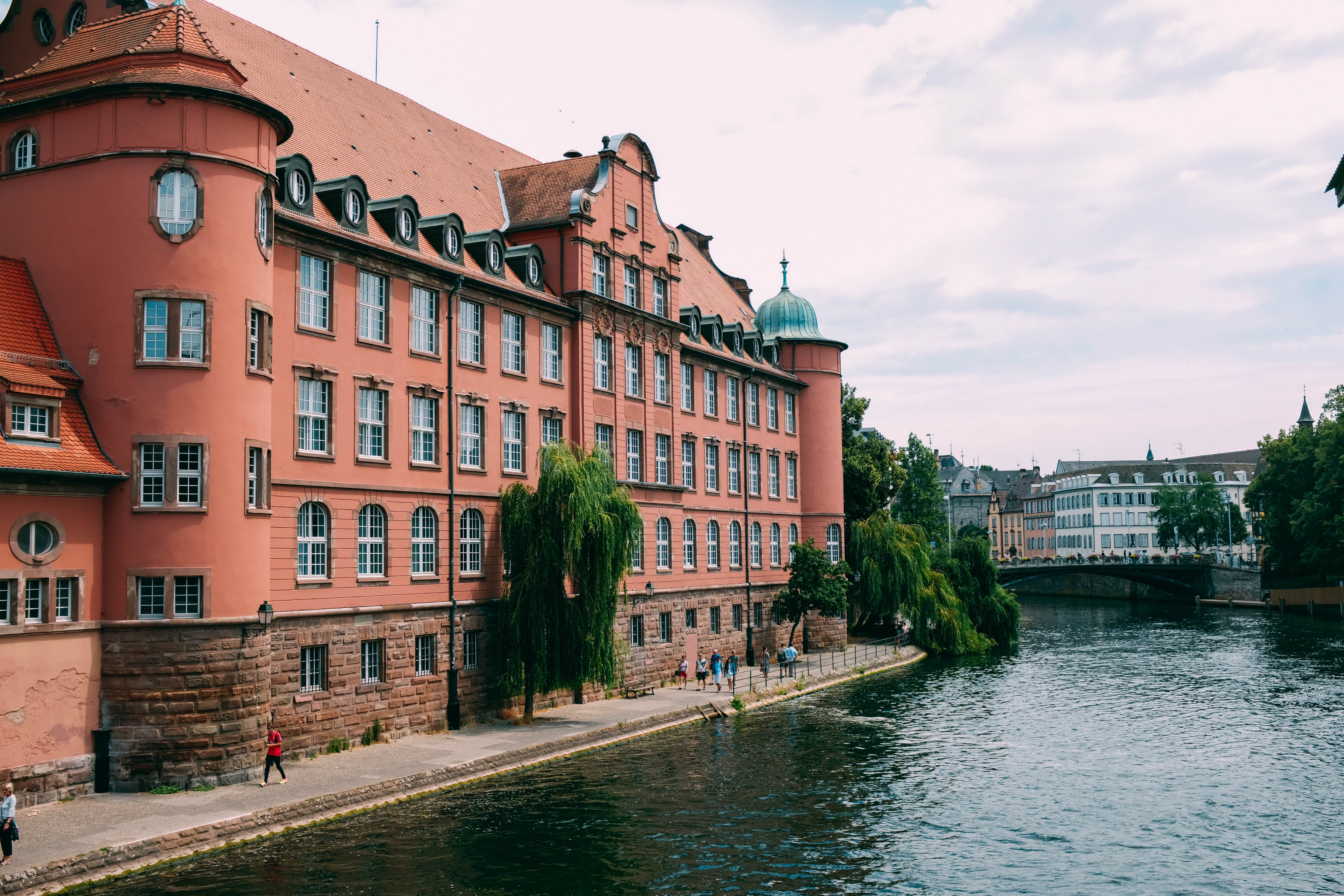 Un edificio in terracotta decorato si affaccia su un fiume Photo 