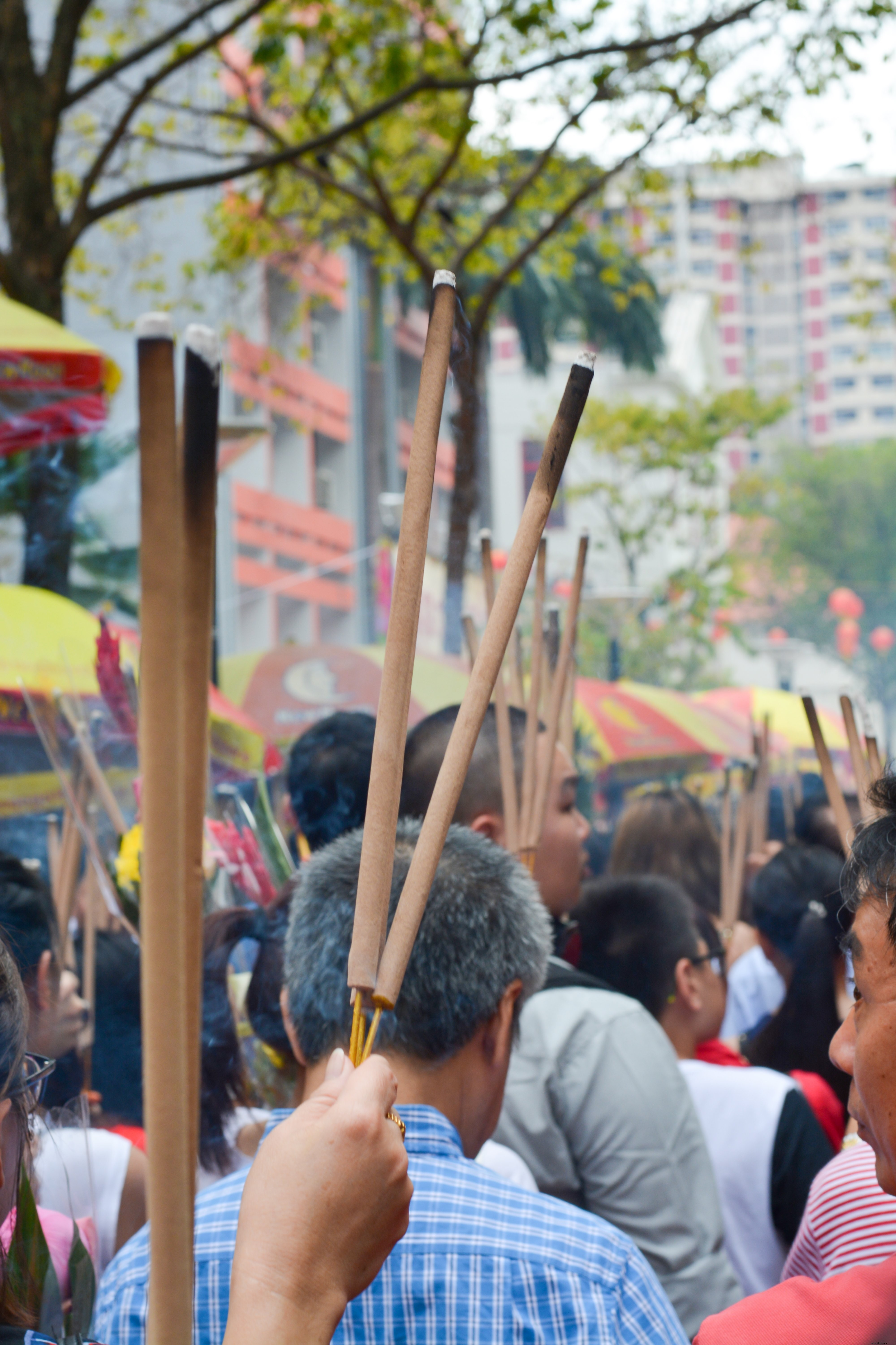 Calle llena de gente sosteniendo palos largos con extremos quemados Foto 
