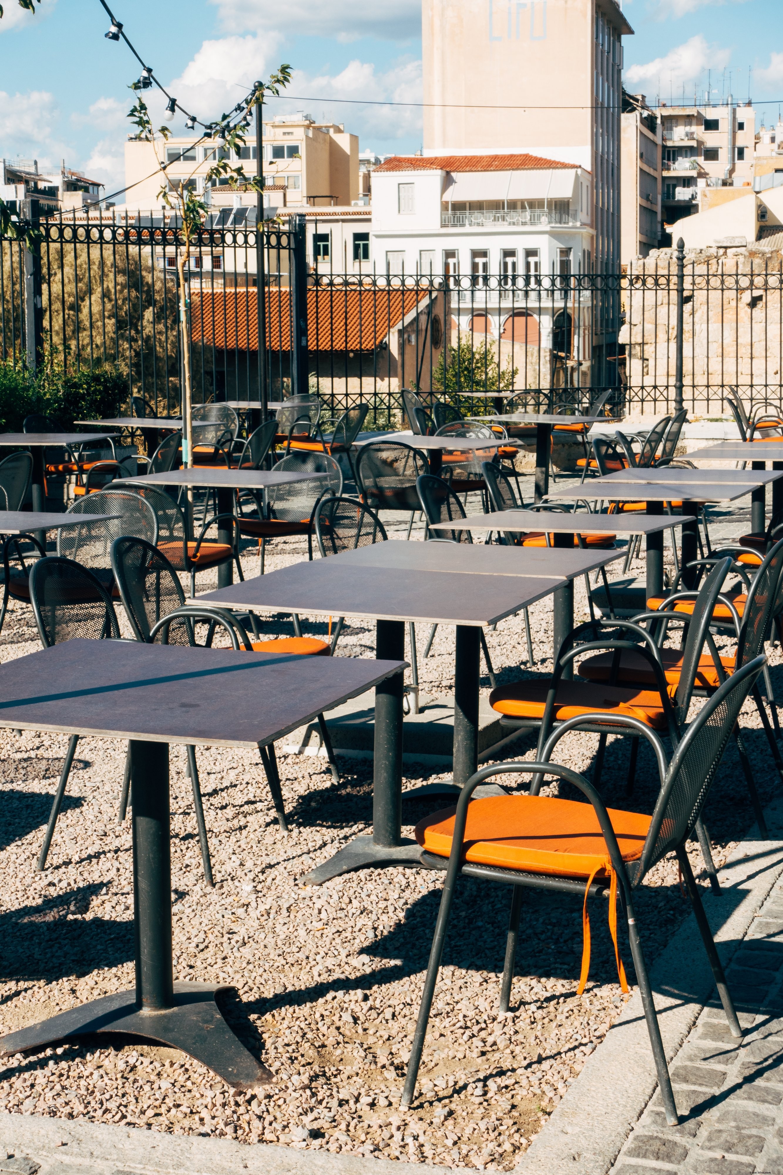 Coussins orange sur des chaises en métal dans un patio vide Photo 