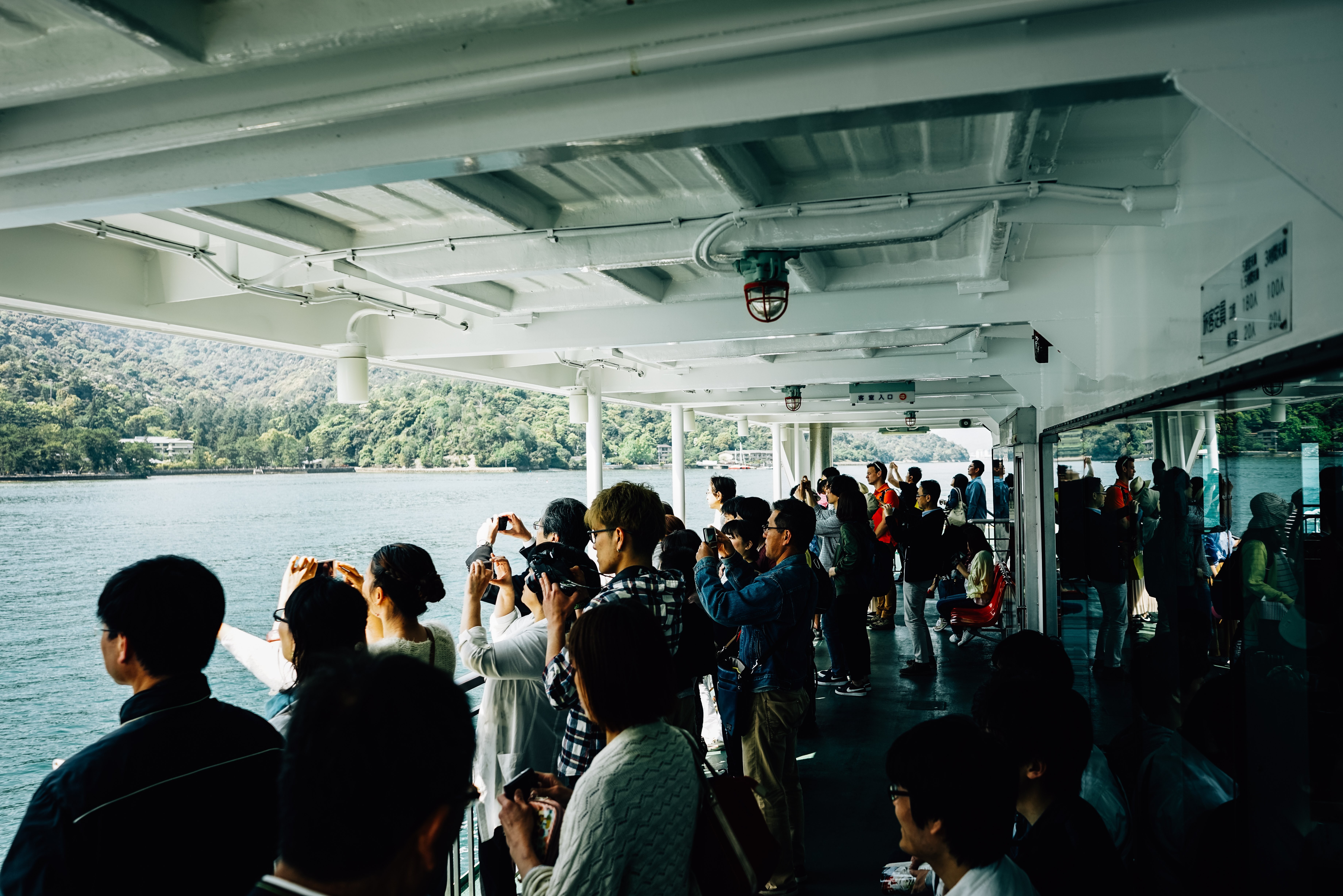 Multidão de pessoas tirando fotos em um barco. 