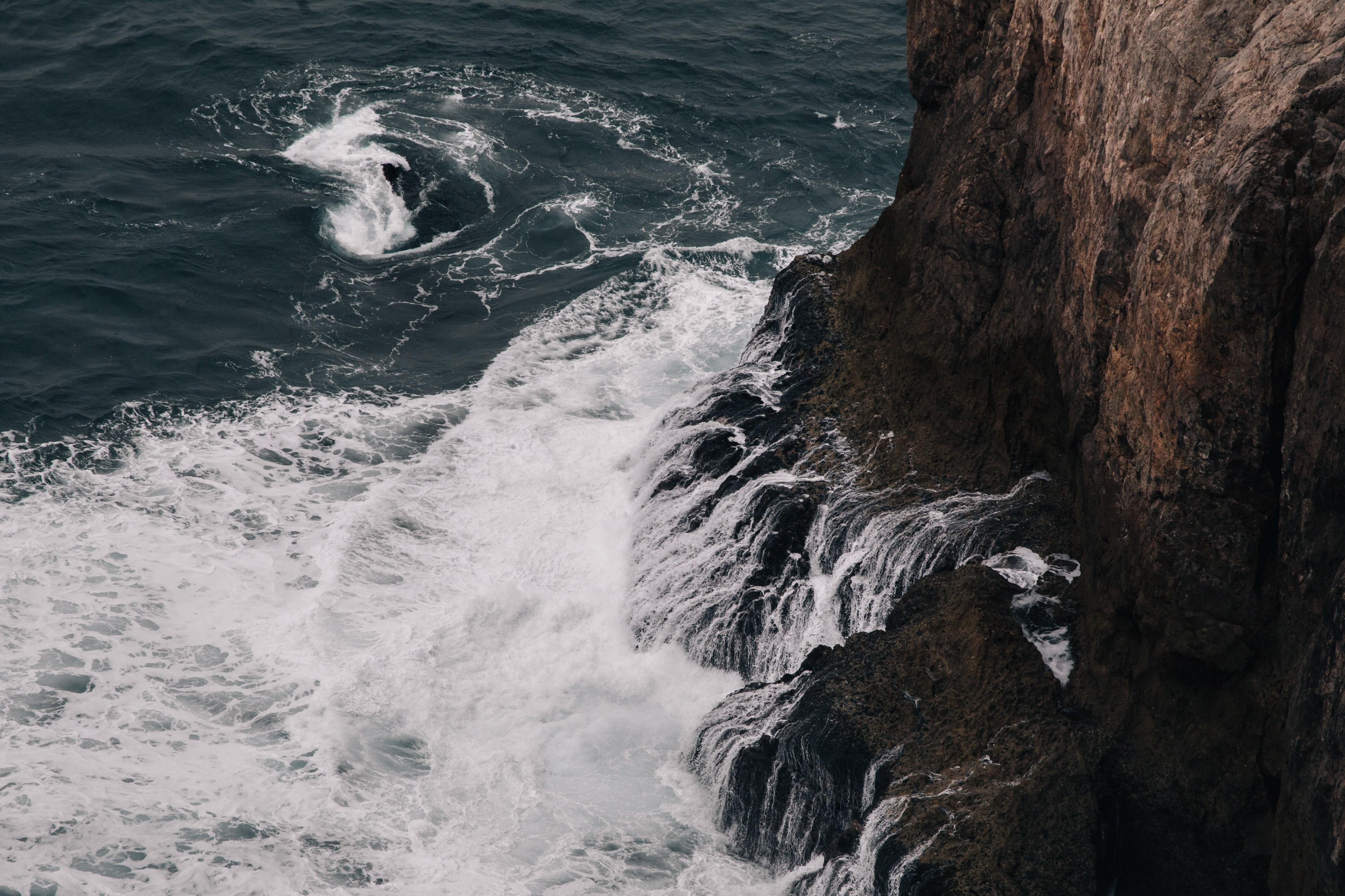 崖の写真の根元にある泡状の波の爪 