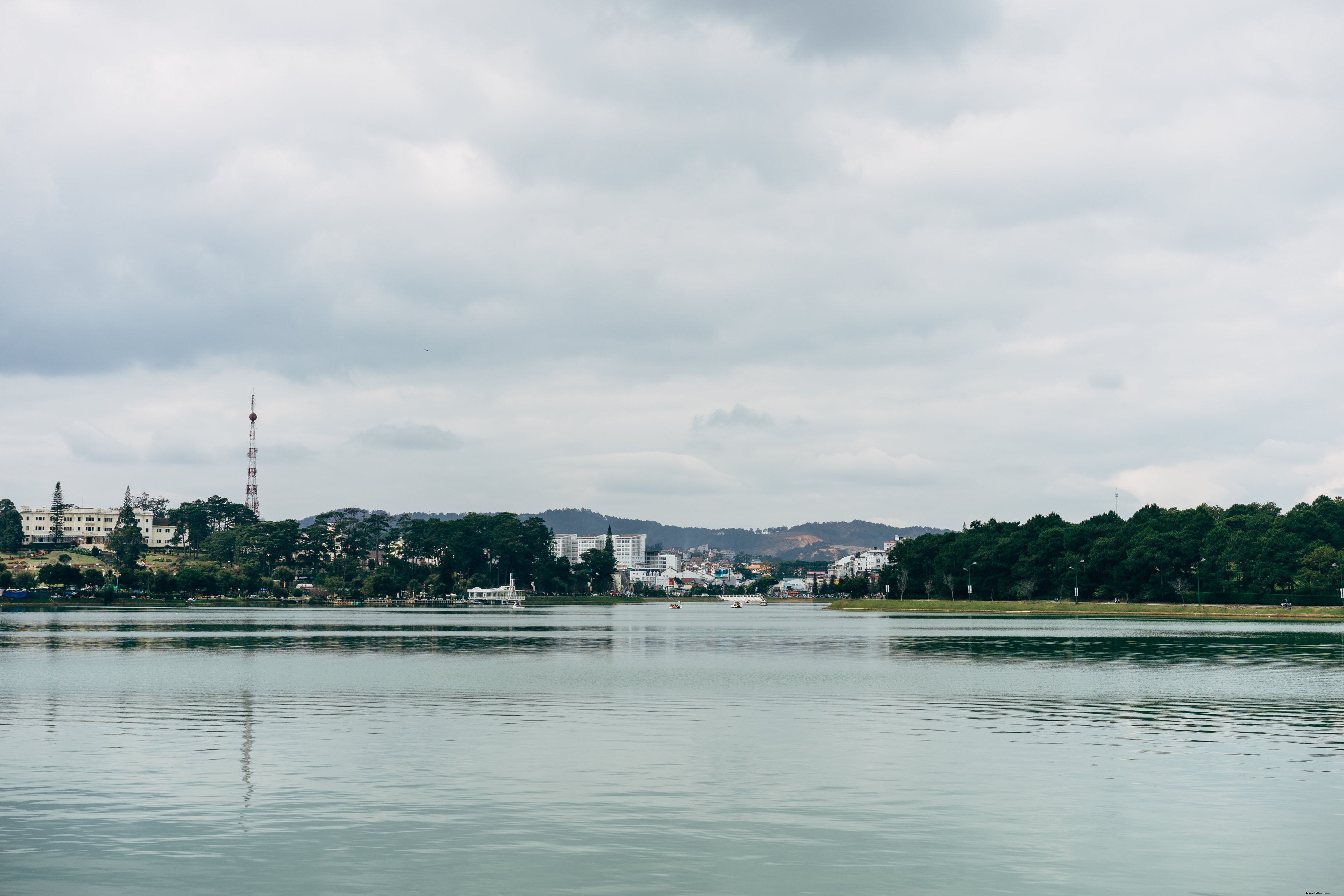 Foto de edificios alineados junto al lago con montañas 