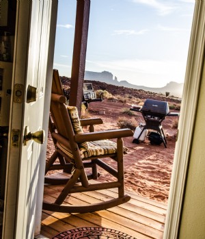 À travers une porte, une chaise à bascule sur un porche surplombe le désert Photo 
