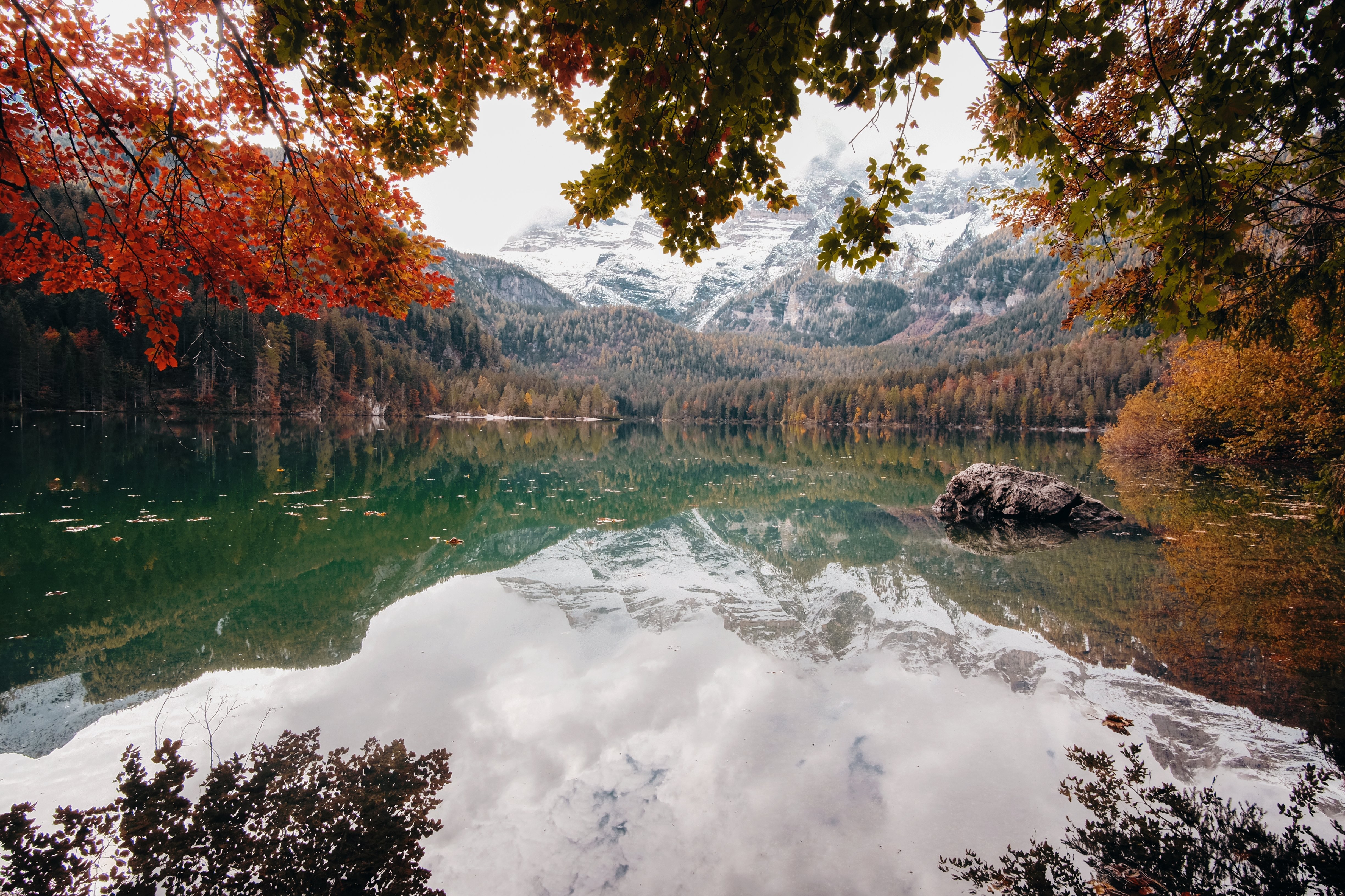 白い帽子をかぶった山々のある湖の秋の景色写真 