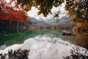 Vista autunnale di un lago con montagne ricoperte di bianco foto 