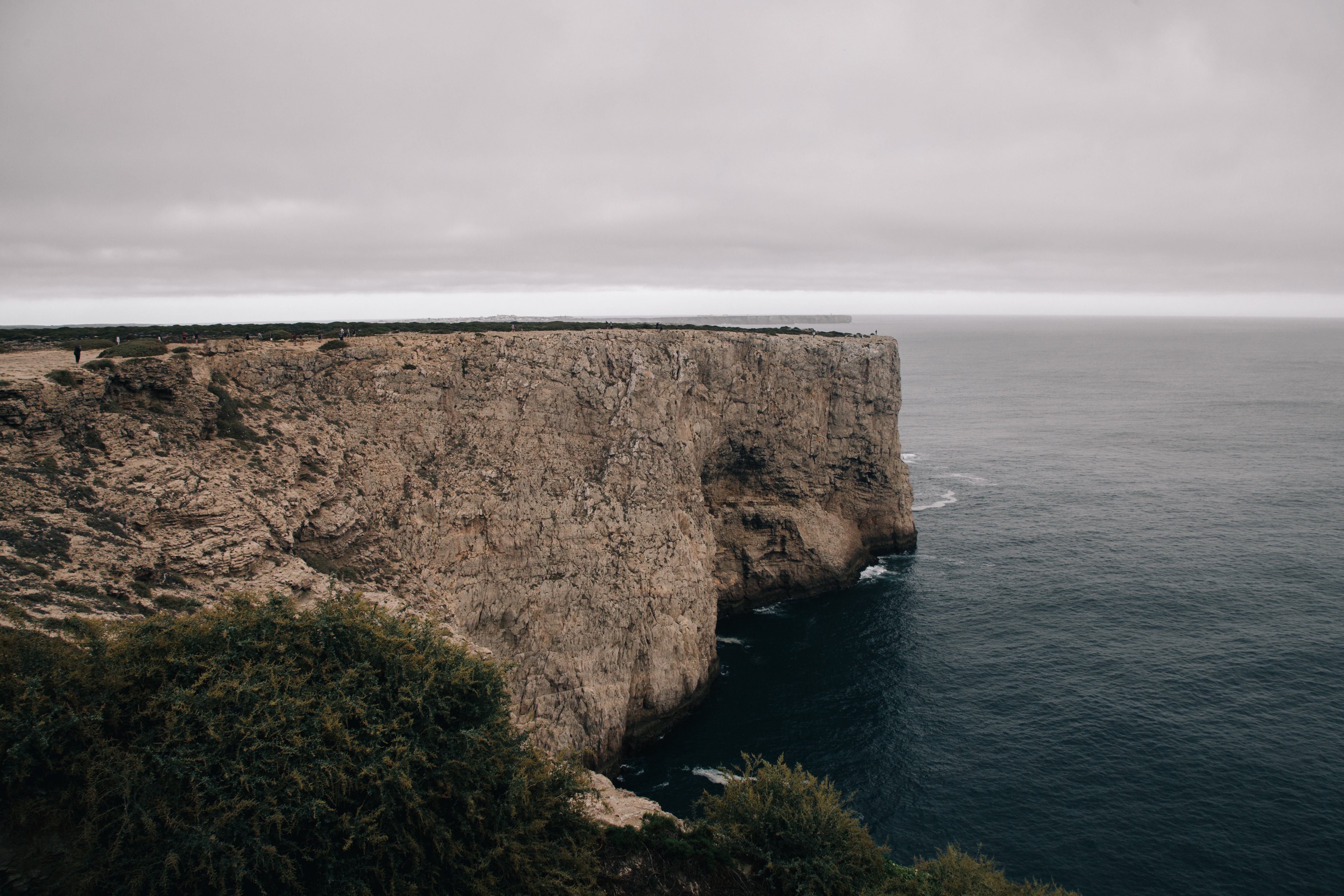 Una larga meseta rocosa se adentra en el frío mar gris Foto 