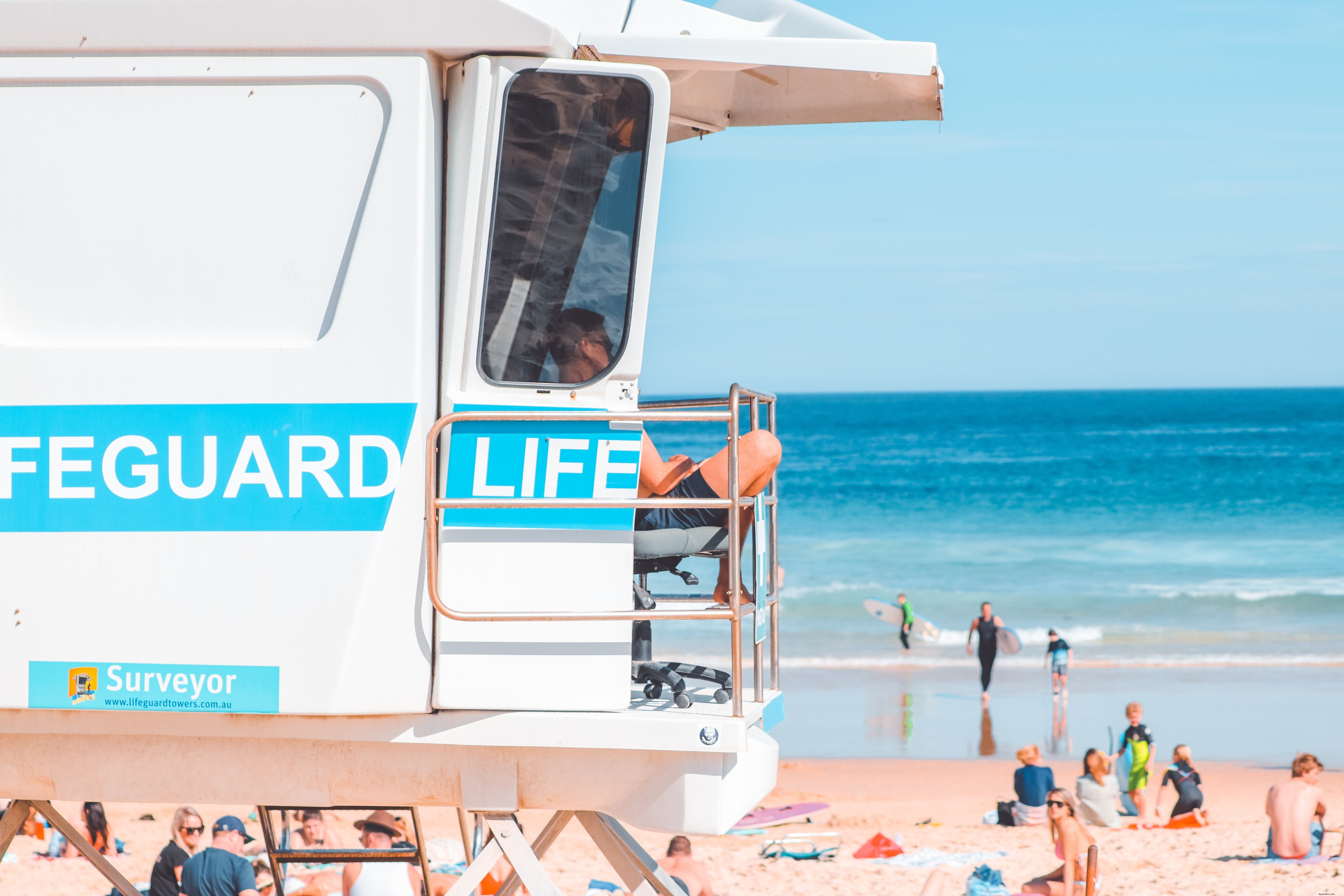 Seorang Penjaga Pantai Duduk Di Foto Stand Putih yang Dibesarkan 