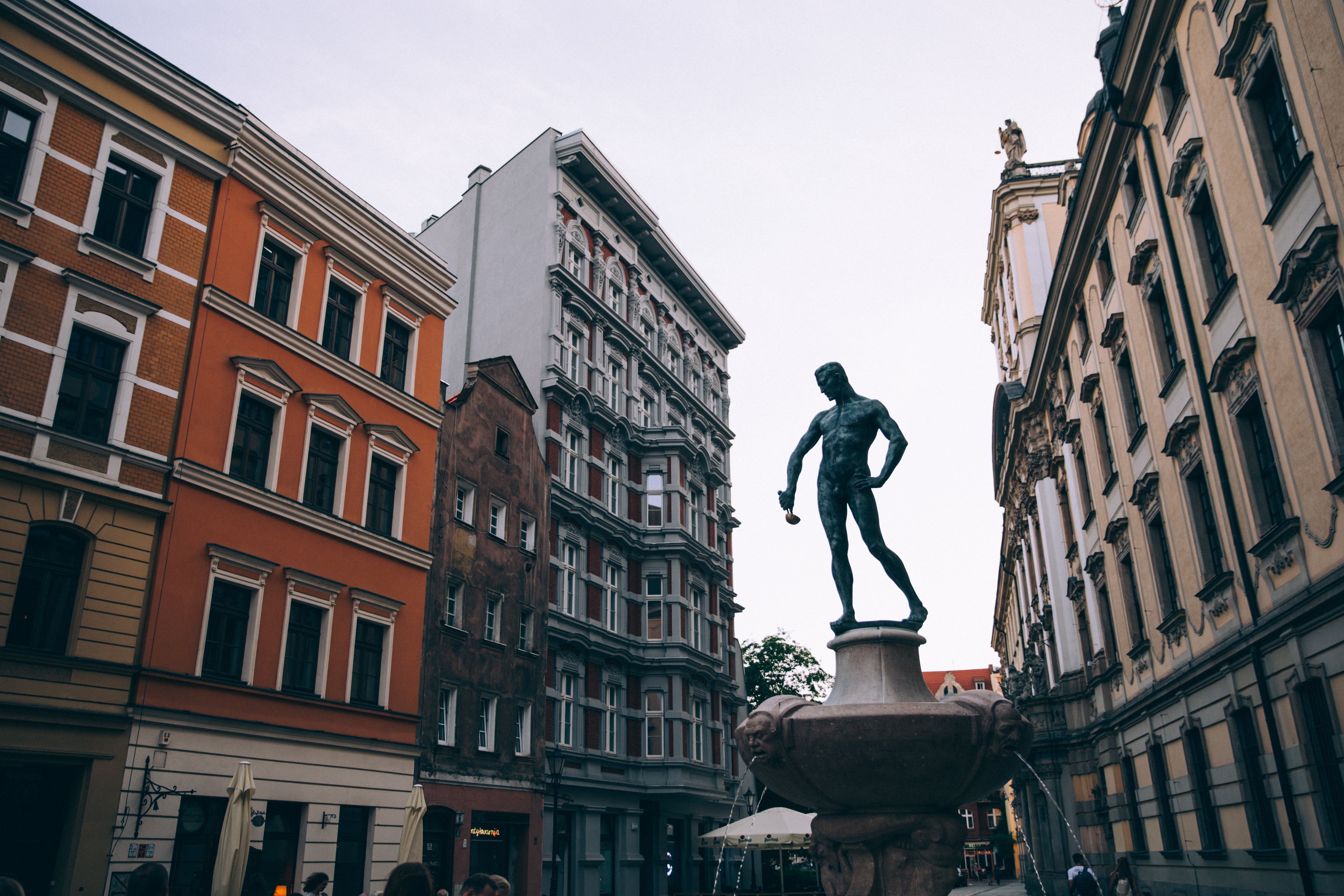 A estátua de um homem segurando uma concha em uma praça da cidade Foto 
