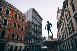 Una statua di un uomo che tiene un mestolo in una piazza della città Foto 