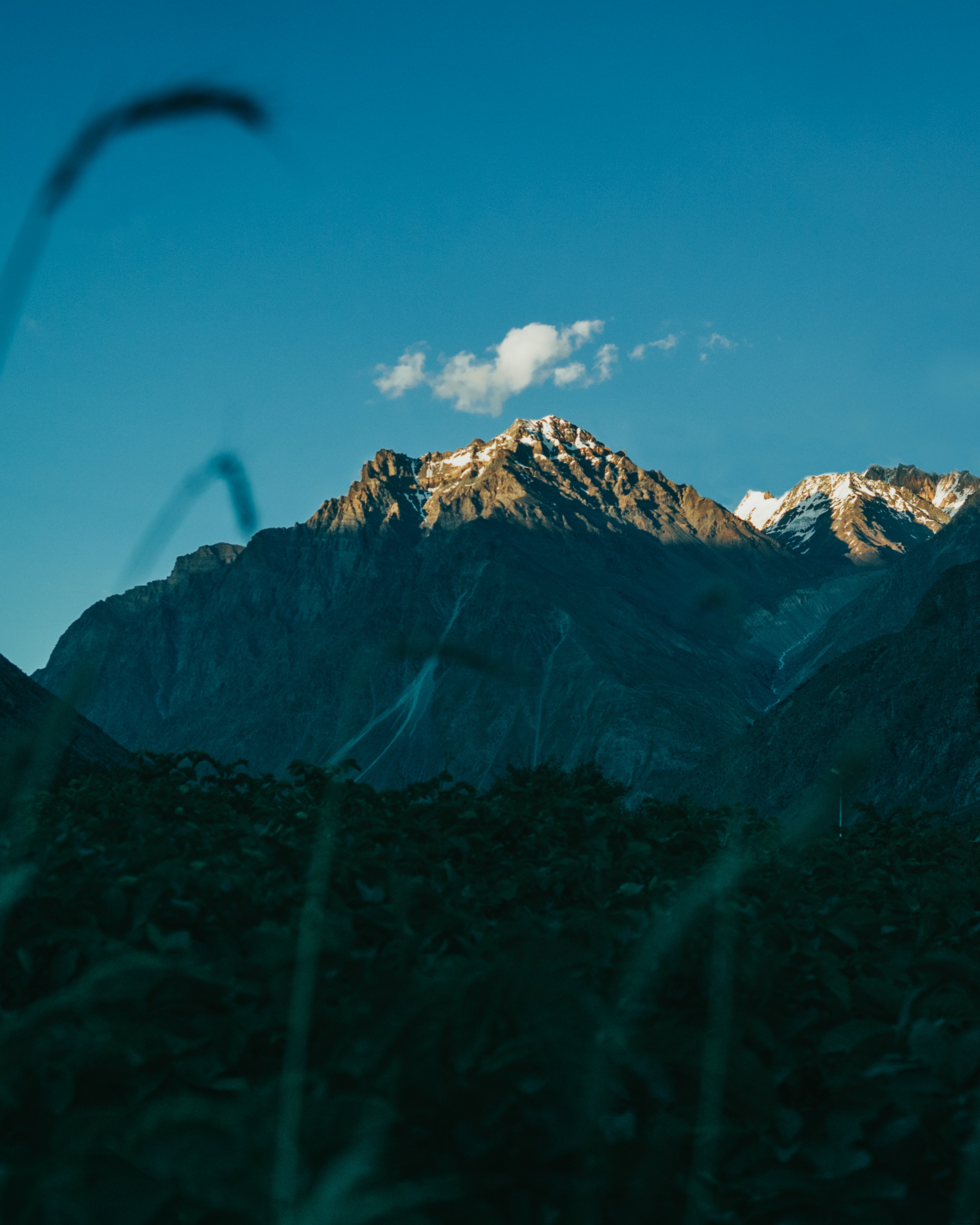 Foto de nuvem única pairando sobre o pico da montanha 