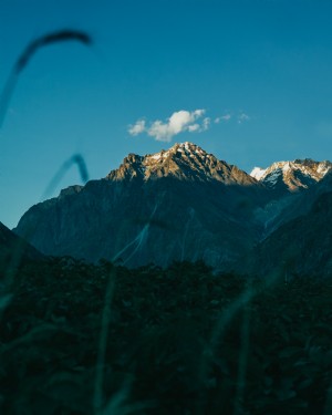 Awan Tunggal Melayang di Atas Foto Puncak Gunung 