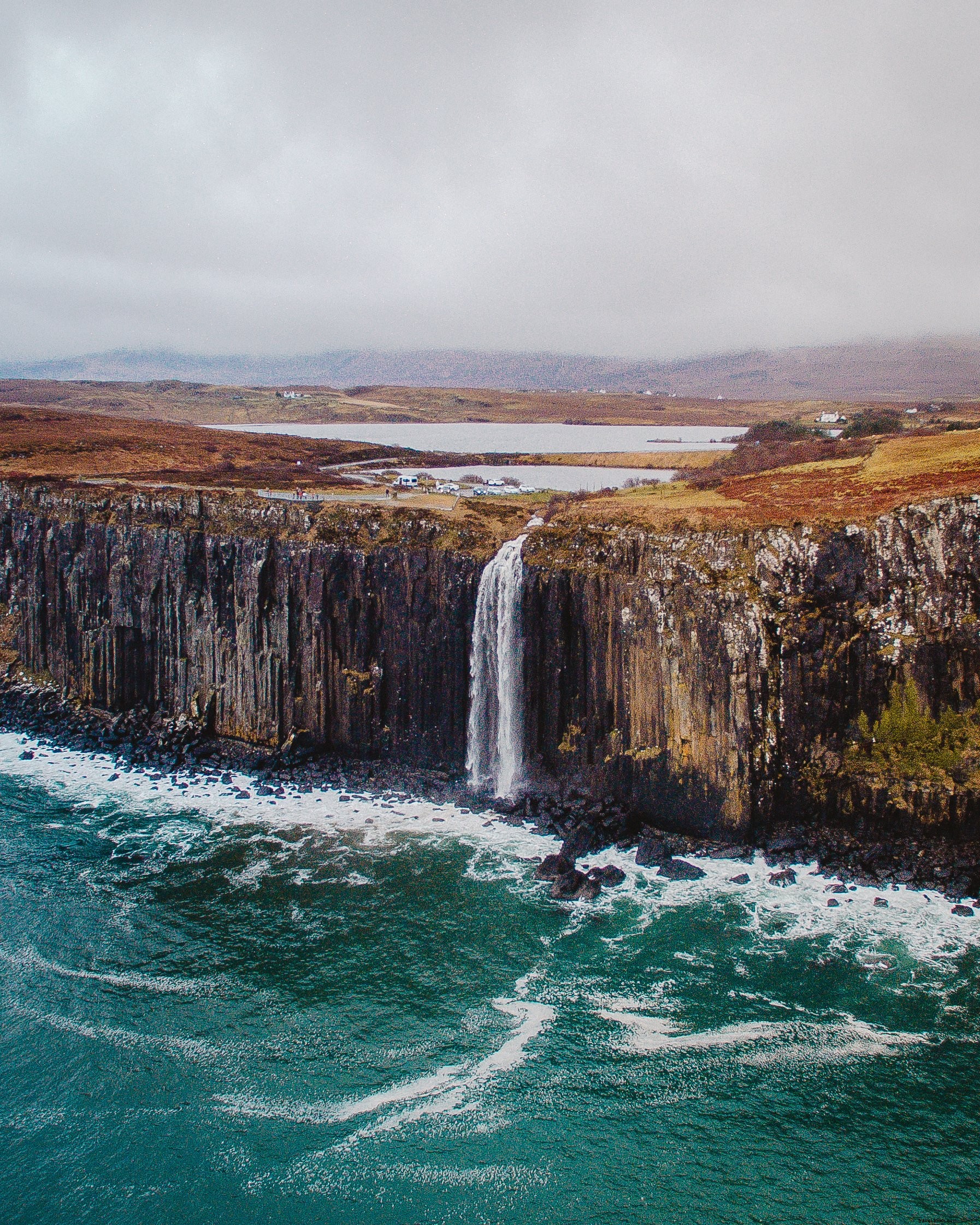 Una cascata cade lungo il lato di una grande scogliera Foto 