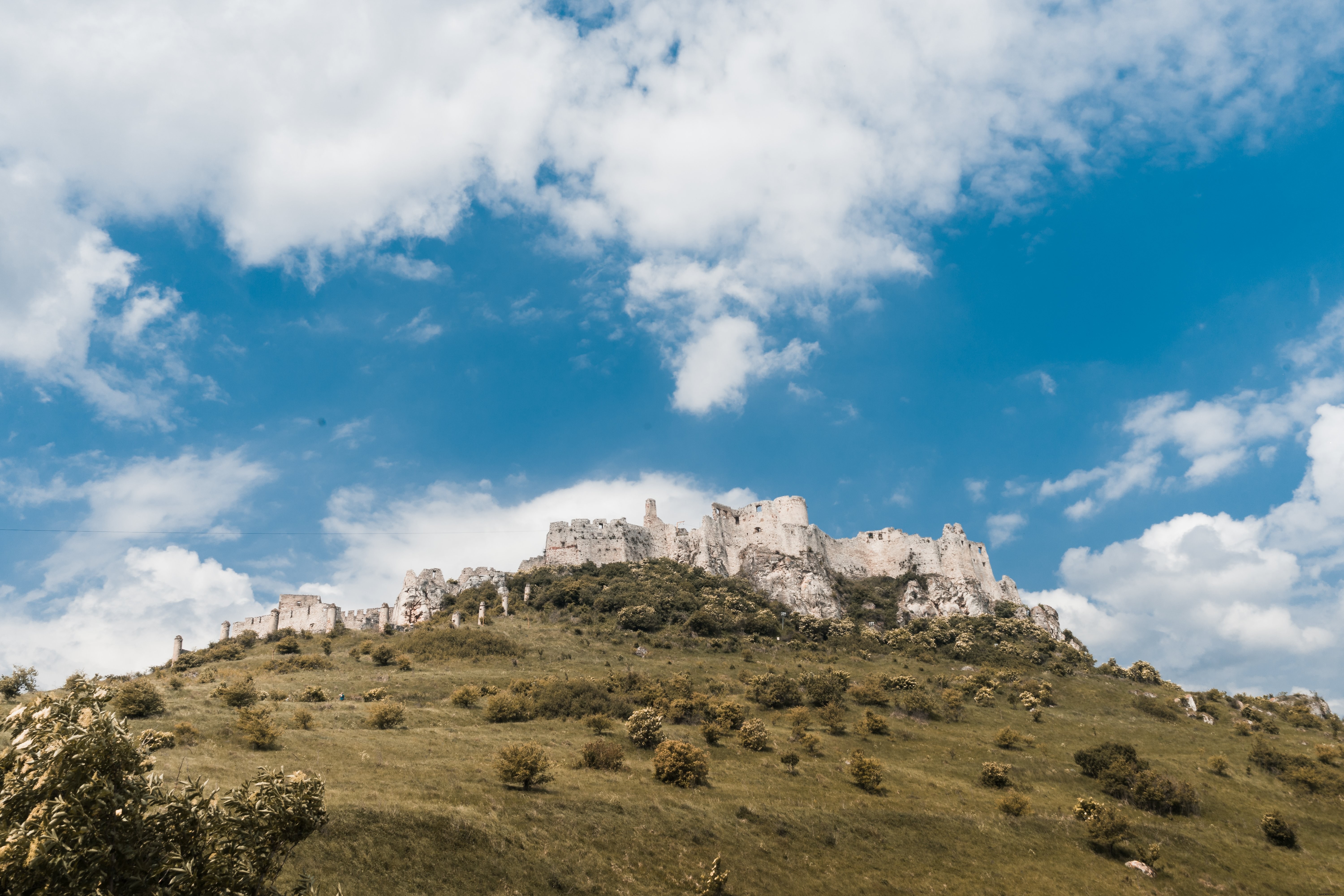 Foto do castelo em uma colina verde 