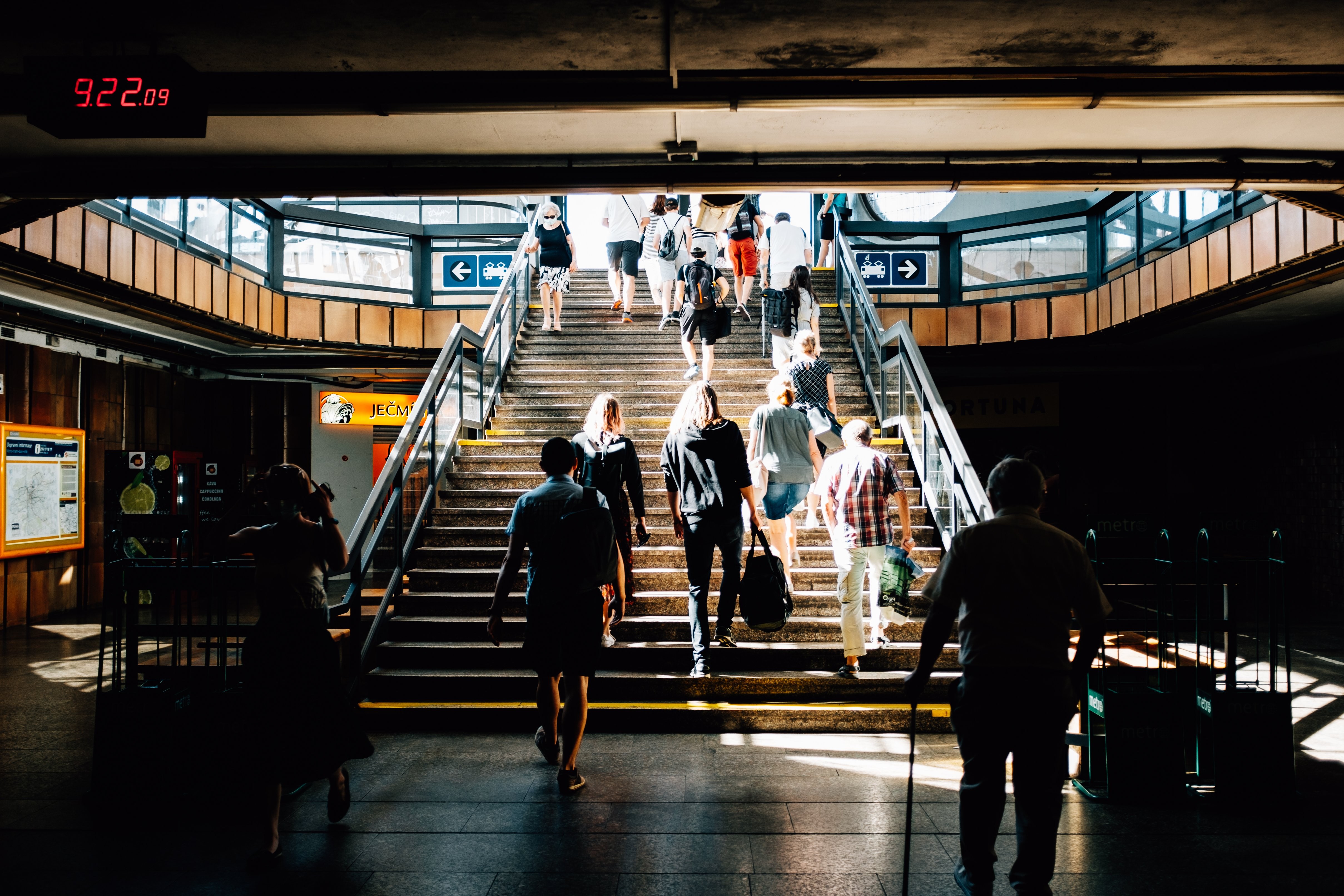 Escalera iluminada en una concurrida foto de la estación 