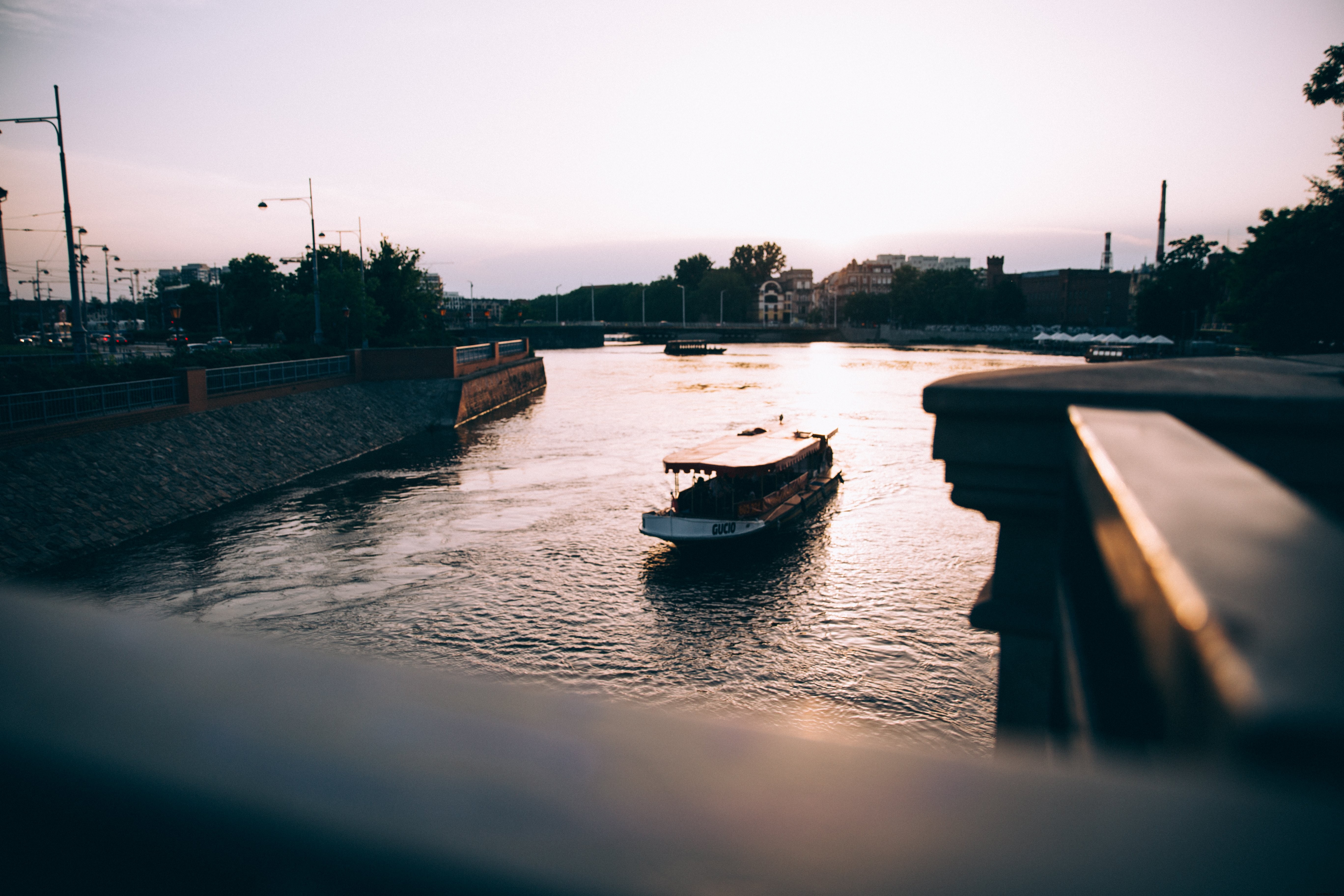 Un barco turístico en un río al atardecer Foto 