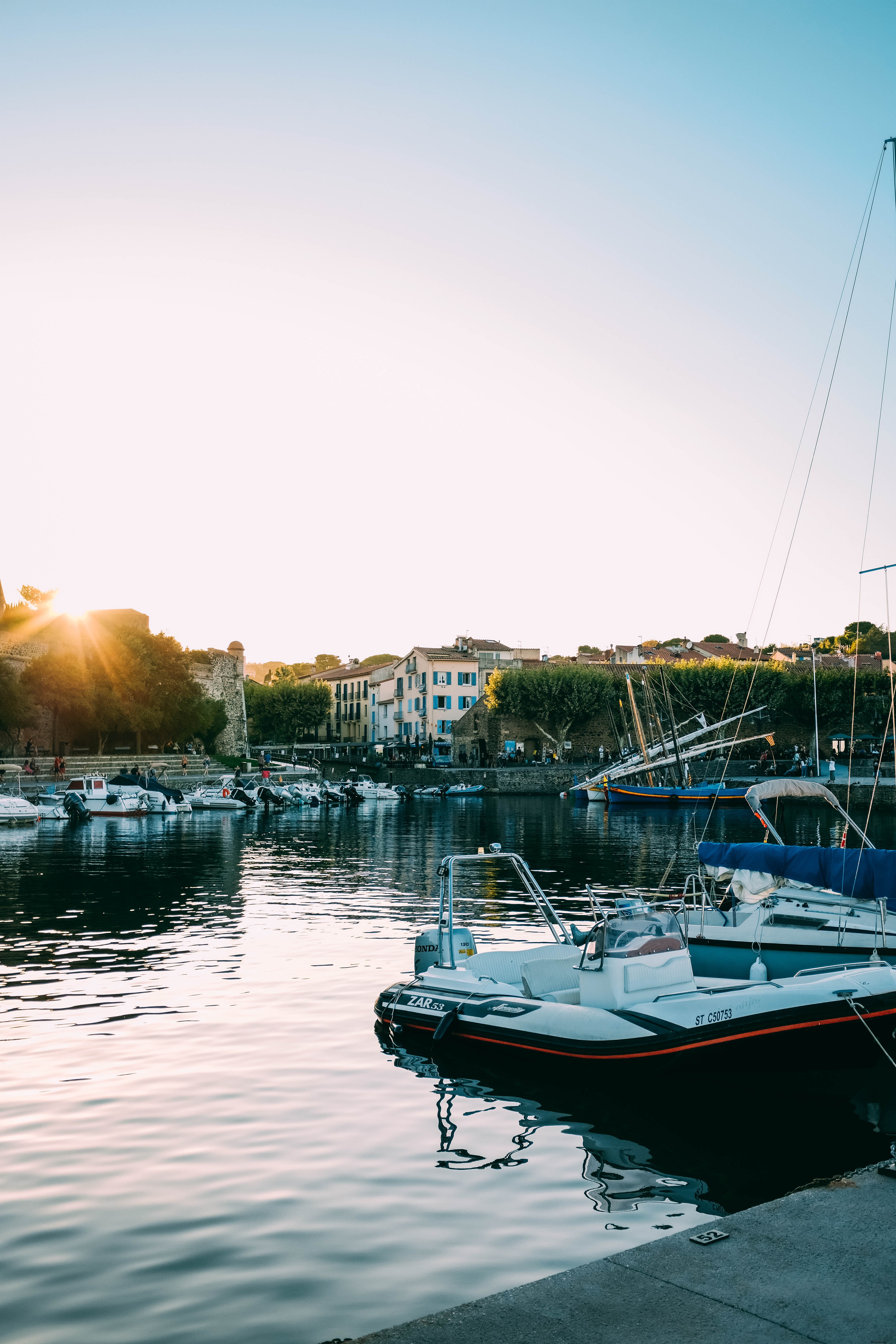 Foto do pôr do sol sobre os barcos em uma marina 