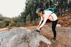 Wanita Berhenti Saat Mendaki Untuk Mengikat Foto Sepatunya 