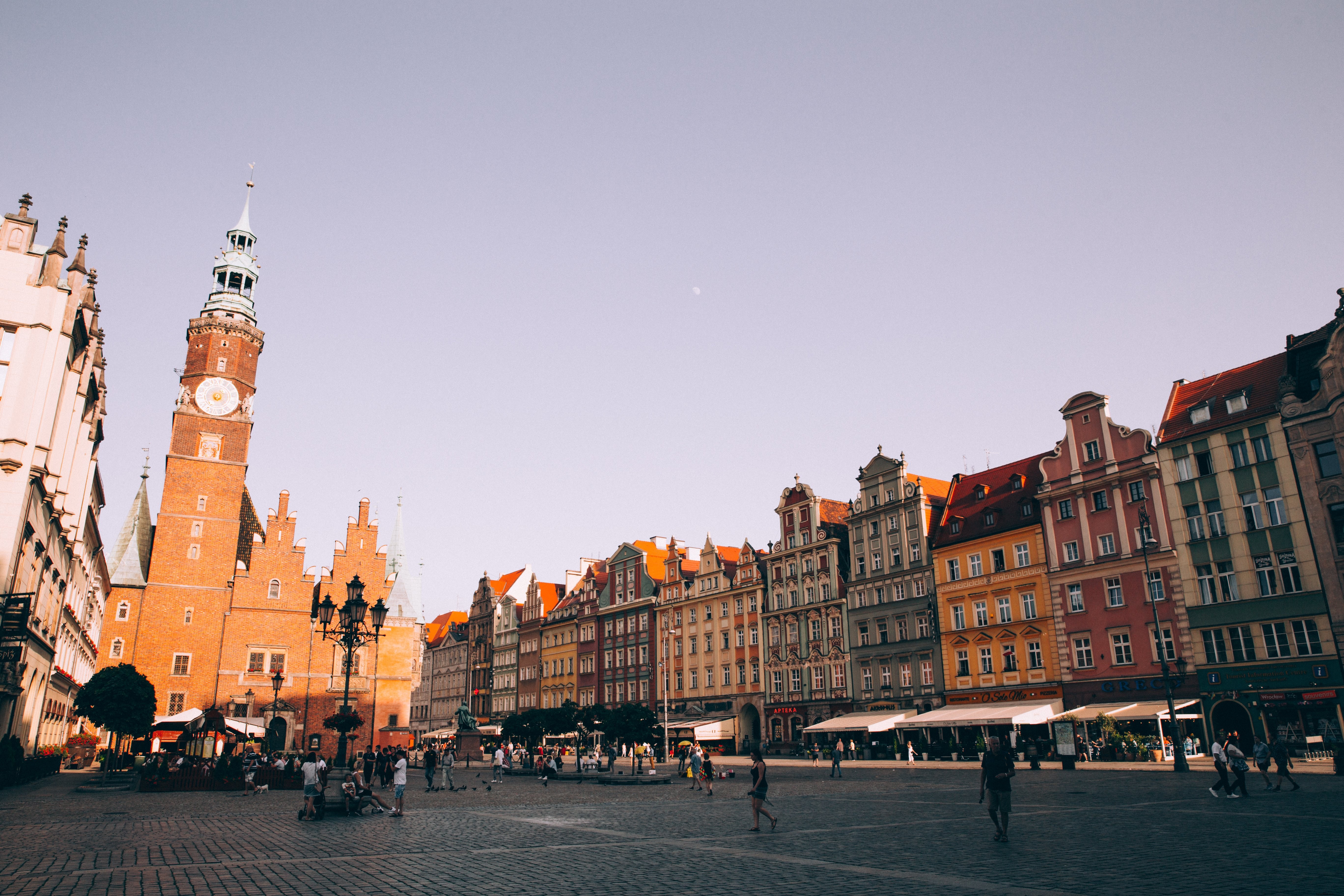 Coucher de soleil sur une tour de briques rouges dans une Piazza Pavée Photo 