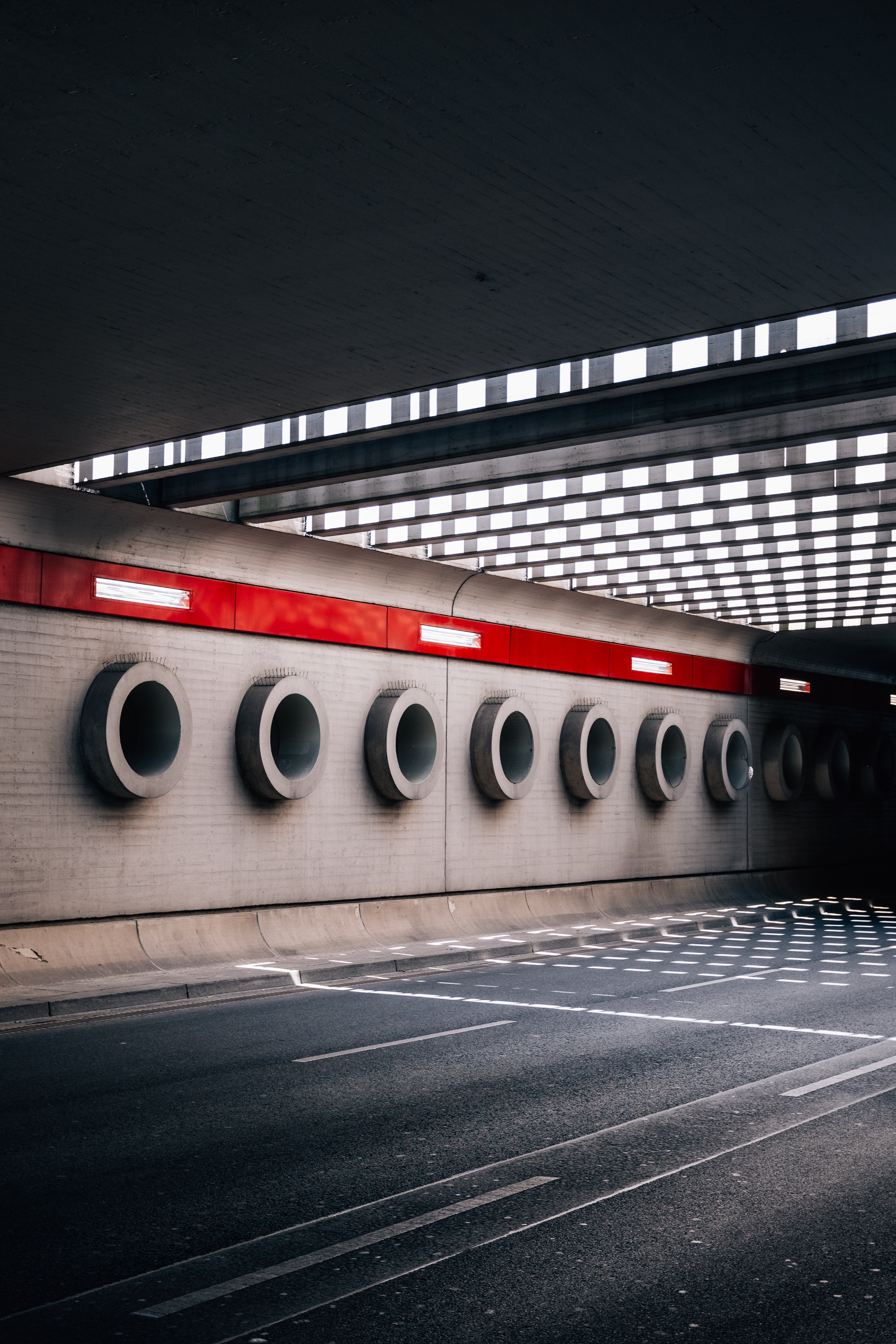 Círculos de cimento alinham a parede sob uma foto do viaduto 