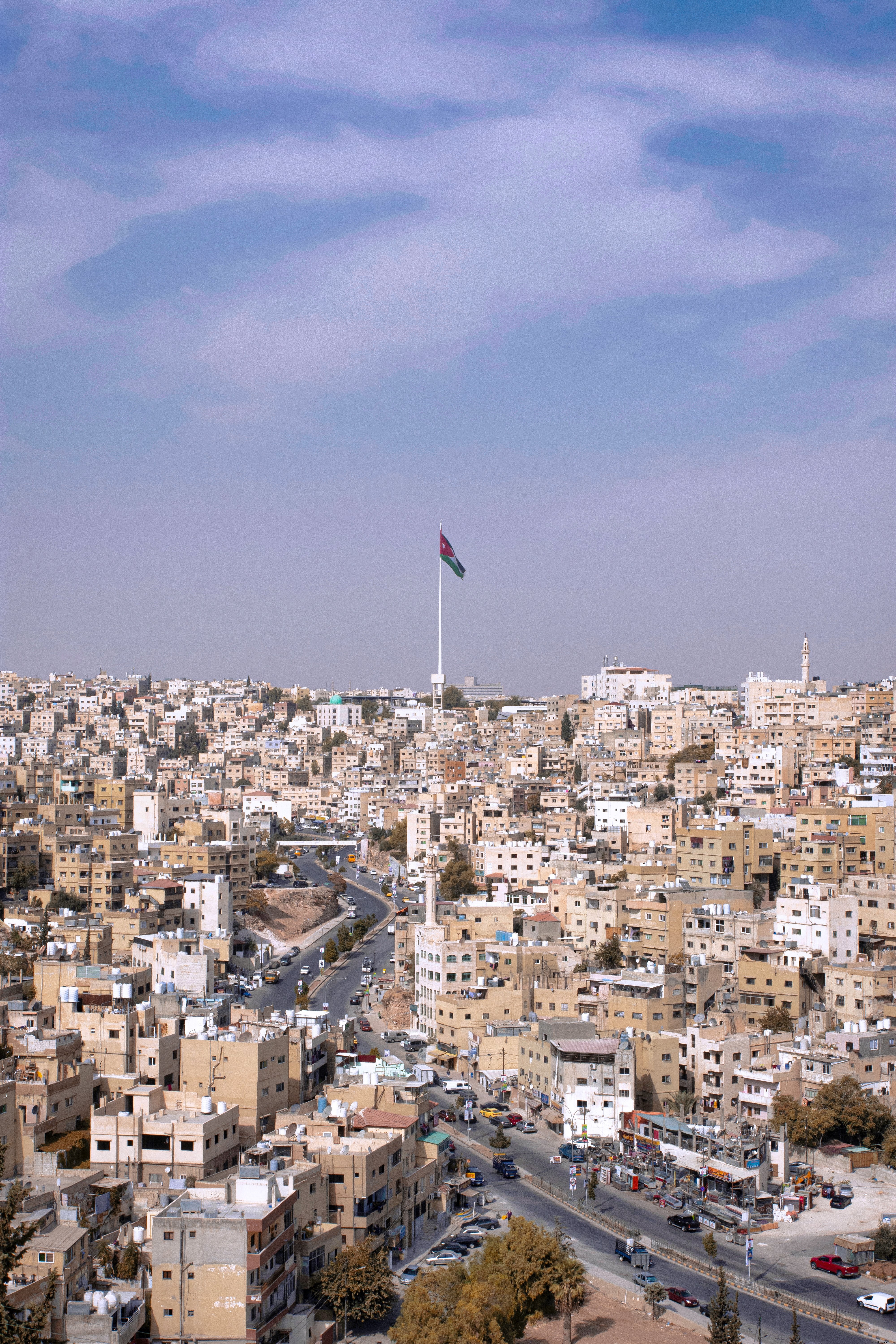 Foto da bandeira nacional da Jordânia sobre a cidade de Jerash 