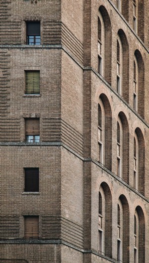 Foto aproximada de um prédio de tijolos marrons com janelas 