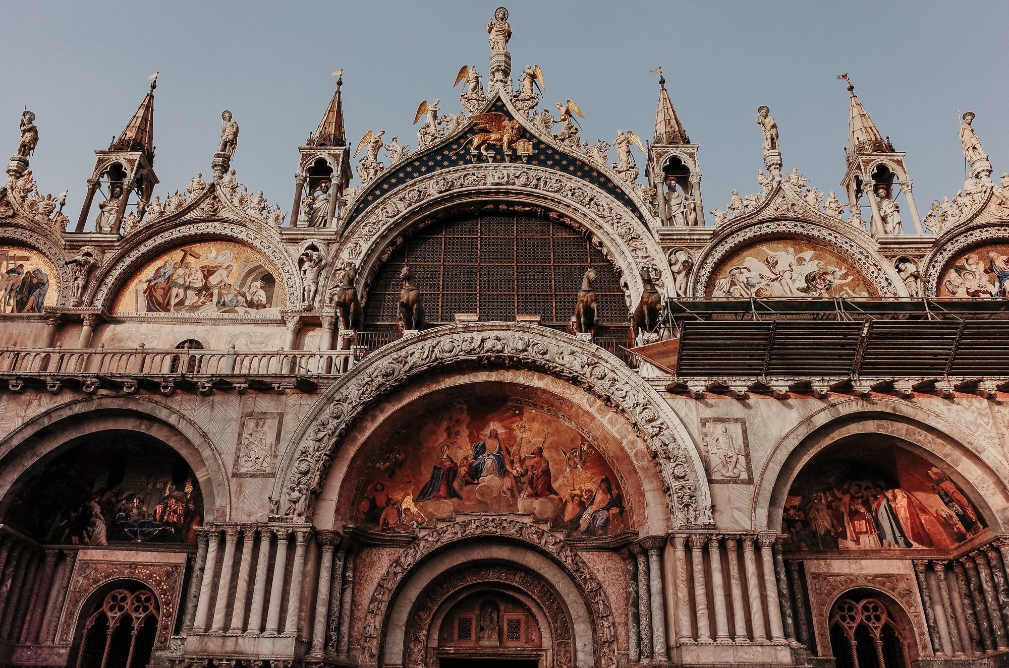 Foto de la parte superior de un edificio religioso con esculturas 