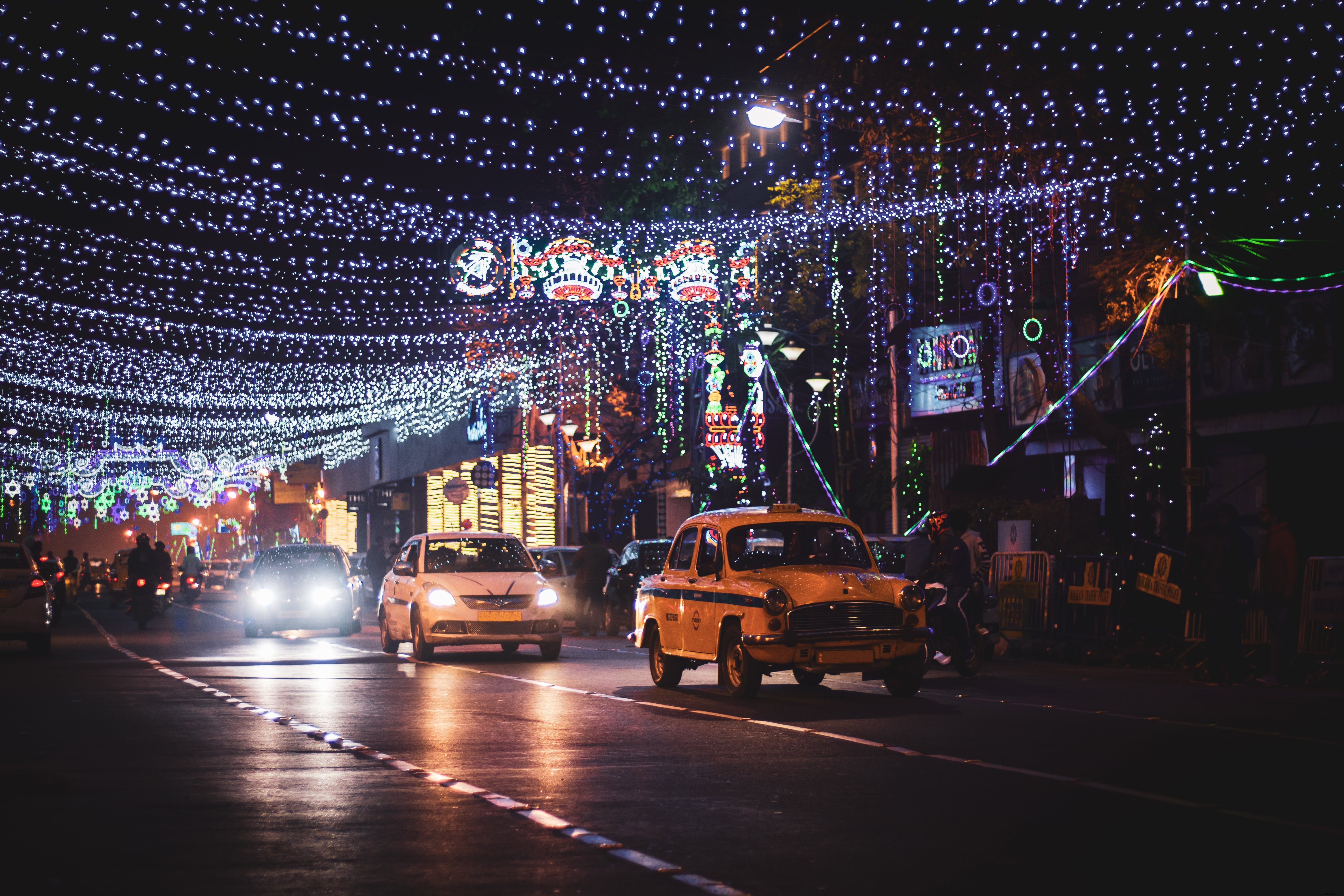 Taxi et autres petites voitures sur une photo de rue de la ville illuminée 