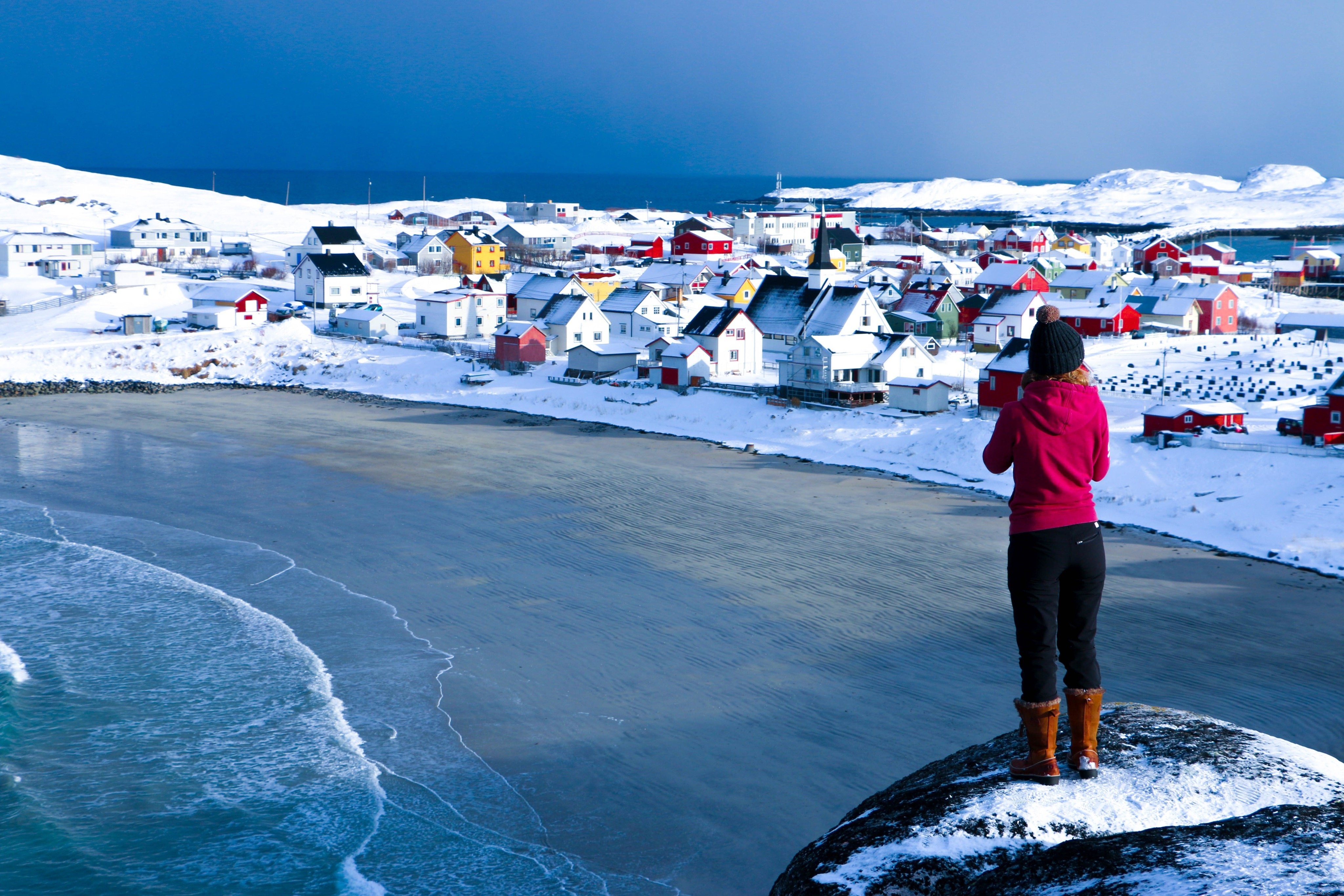 Foto de acantilado sobre la playa de arena de invierno y casas coloridas 