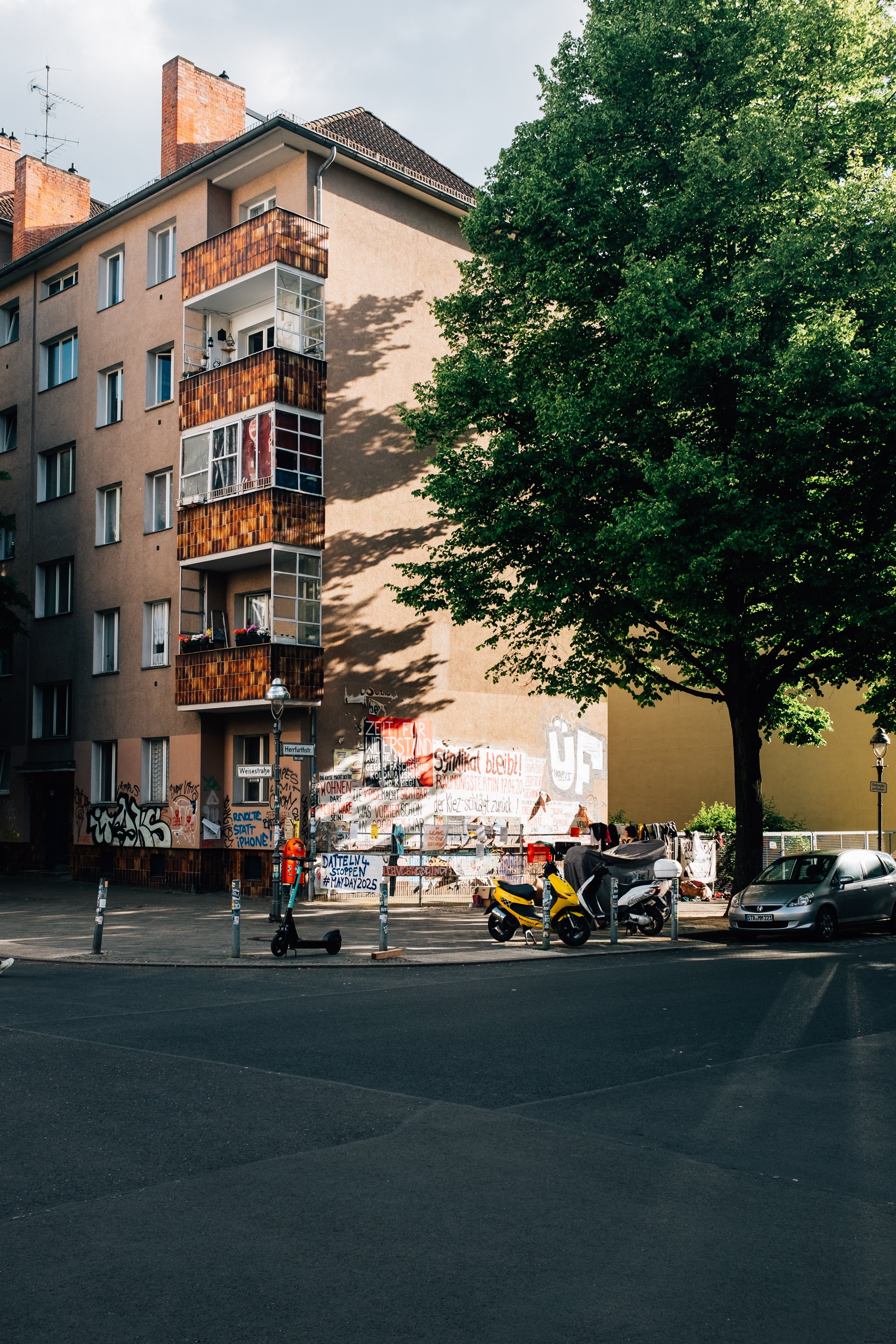 Edificio de poca altura con graffiti y una gran foto de árbol verde 