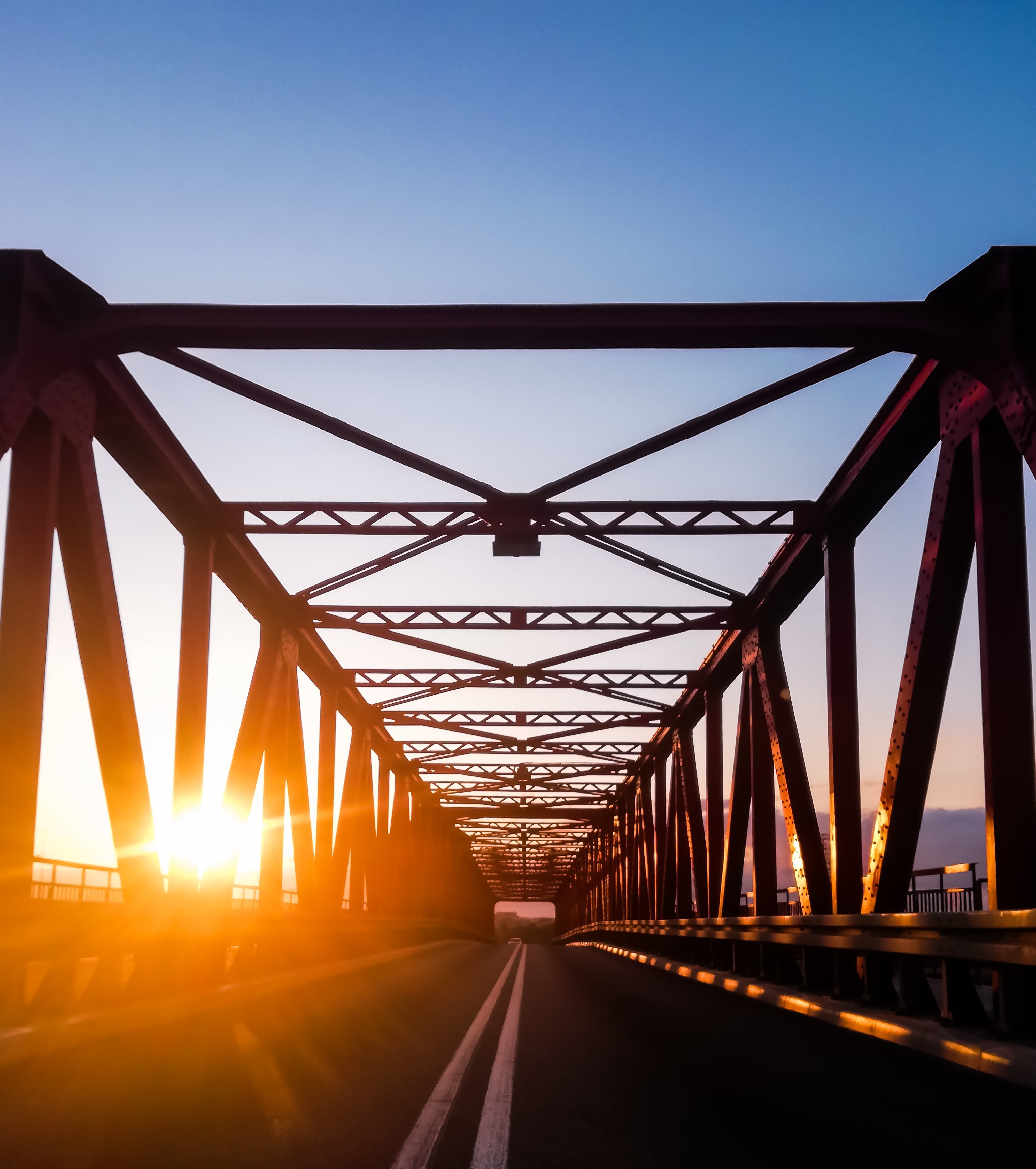 Foto do pôr do sol na estrada de uma ponte pavimentada 